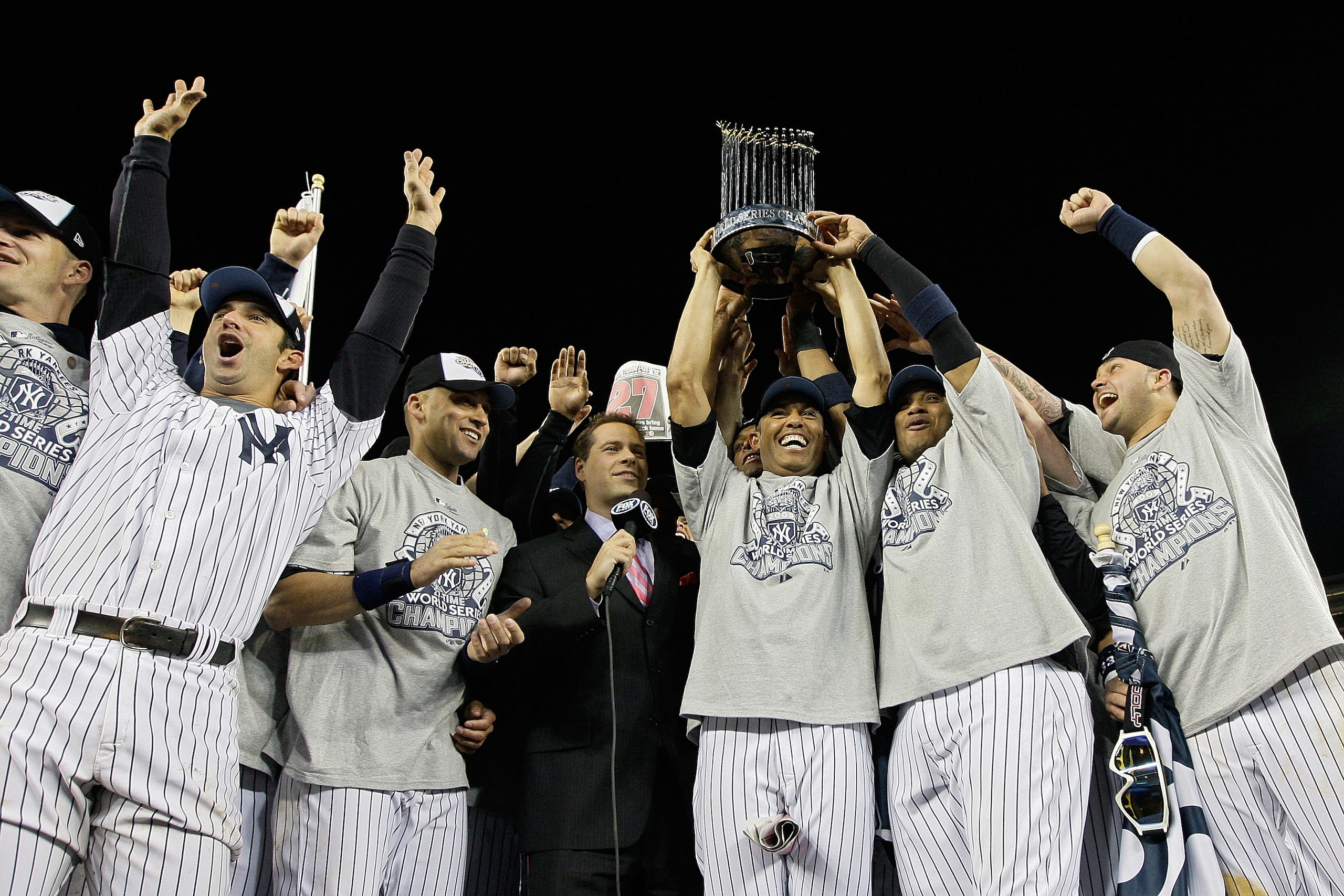 NEW YORK - NOVEMBER 04:  Mariano Rivera #42 of the New York Yankees holds the trophy as he celebrates with Derek Jeter #2, Jorge Posada #20 and other teammates celebrates with the trophy after their 7-3 win against the Philadelphia Phillies in Game Six of