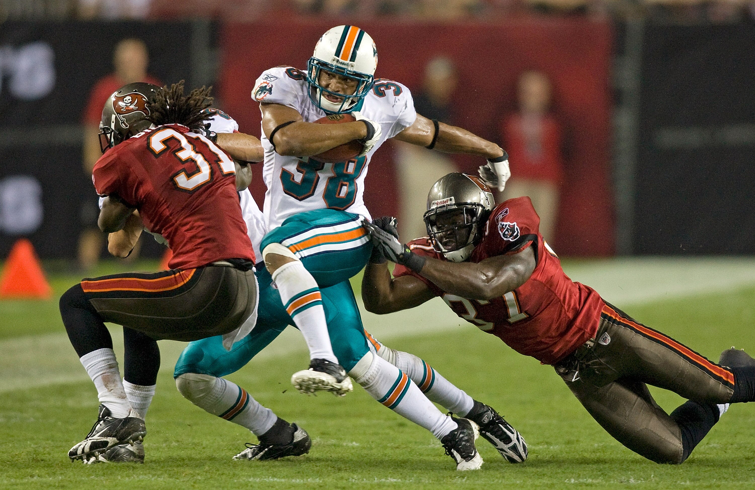 TAMPA, FL - AUGUST 27:  Running back Patrick Cobbs #38 of the Miami Dolphins  is tackled by defender Steve Cargile #37 of the Tampa Bay Buccaneers during a preseason game at Raymond James Stadium on August 27, 2009 in Tampa, Florida.  (Photo by J. Meric/G