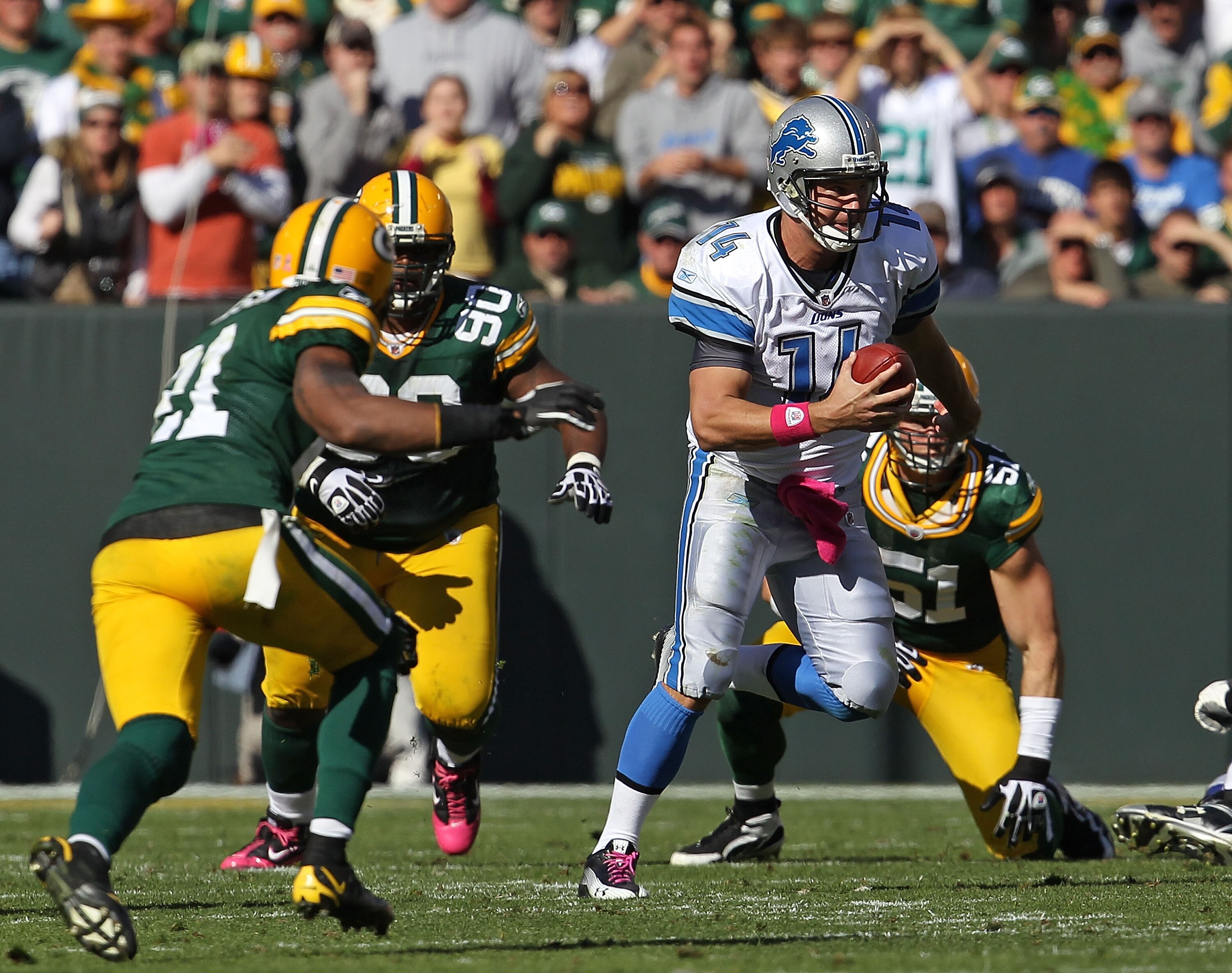 GREEN BAY, WI - OCTOBER 03: Shaun Hill #14 of the Detroit Lions runs for a first down pursued by Charles Woodson #21 and B.J. Raji #90 of the Green Bay Packers at Lambeau Field on October 3, 2010 in Green Bay, Wisconsin. The Packers defeated the Lions 28-