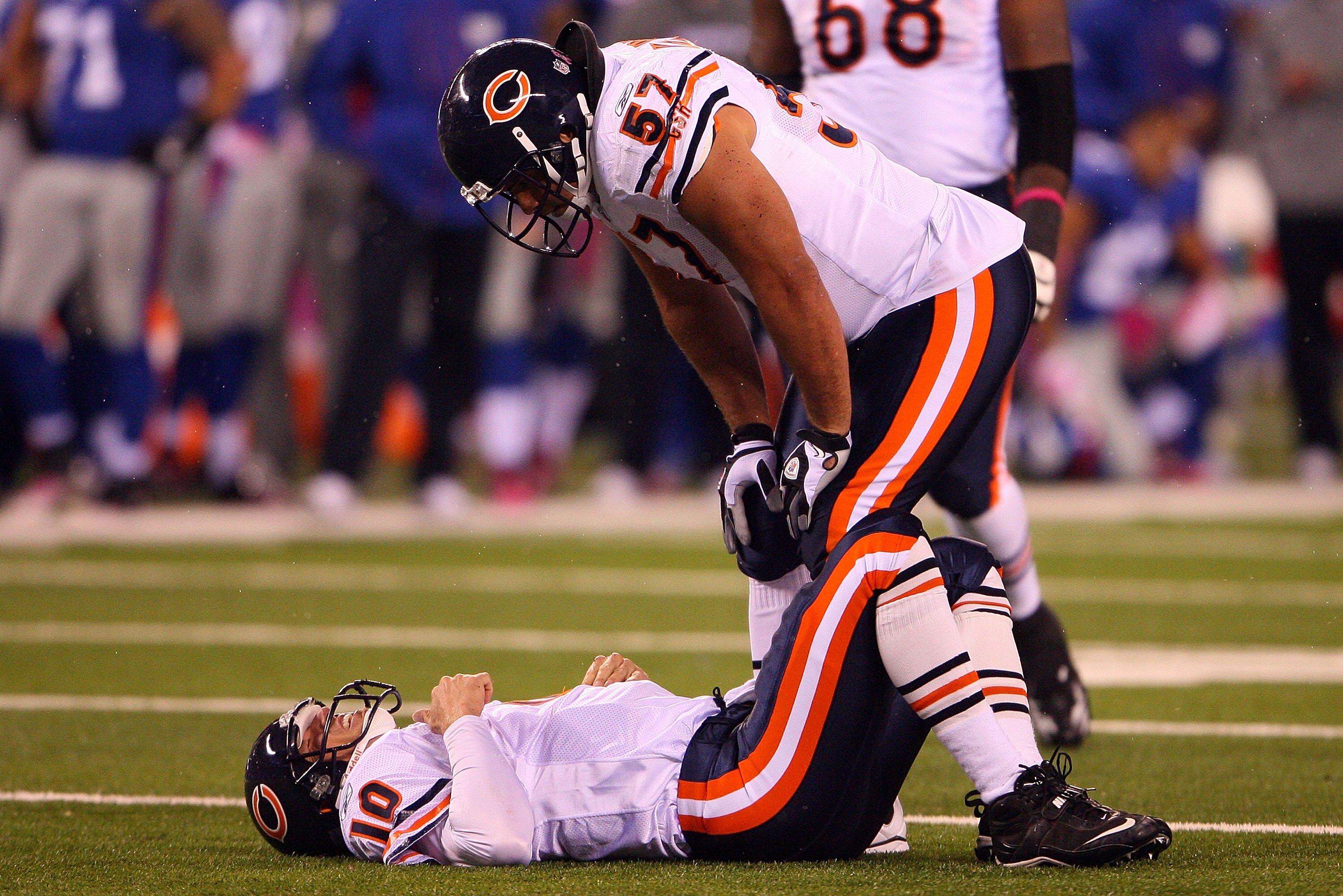 EAST RUTHERFORD, NJ - OCTOBER 03:  Olin Kreutz #57 looks at Todd Collins #10 of the Chicago Bears as he lays on the field after getting injured against the New York Giants at New Meadowlands Stadium on October 3, 2010 in East Rutherford, New Jersey.  (Pho