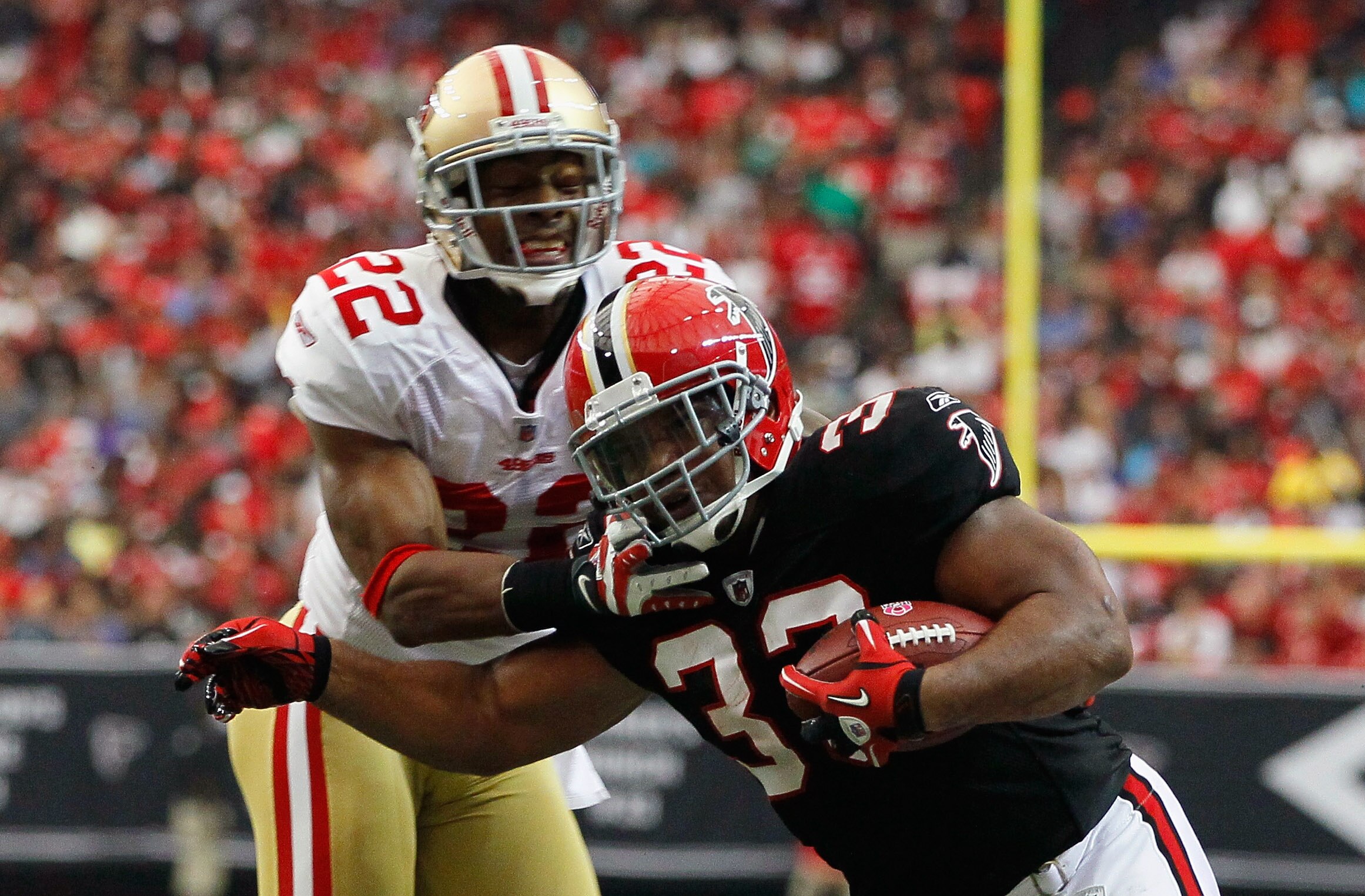 ATLANTA - OCTOBER 03:  Michael Turner #33 of the Atlanta Falcons breaks a tackle by Nate Clements #22 of the San Francisco 49ers at Georgia Dome on October 3, 2010 in Atlanta, Georgia.  (Photo by Kevin C. Cox/Getty Images)