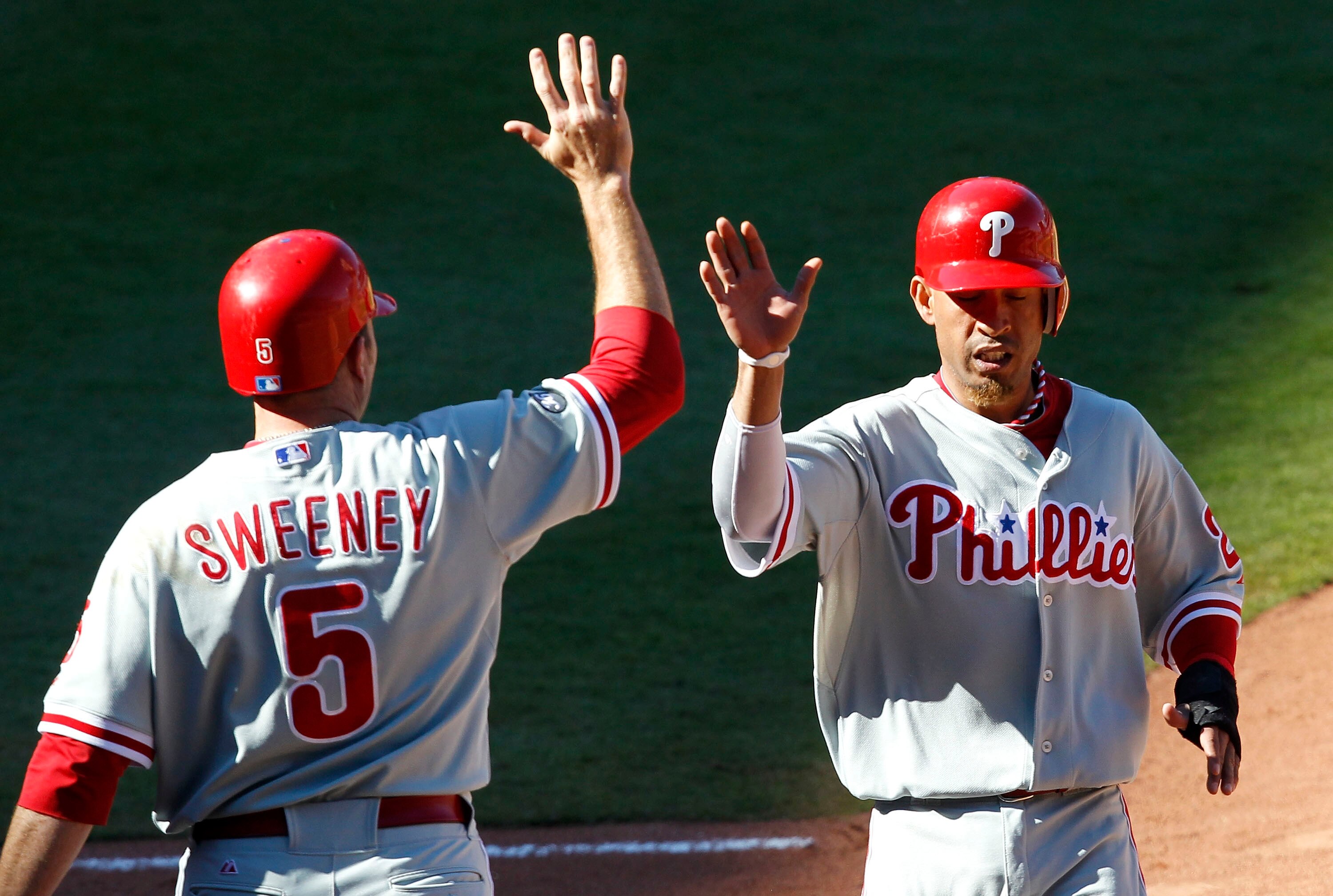 ATLANTA - OCTOBER 3:  Infielder Mike Sweeney #5 of the Philadelphia Phillies congratulates teammate Wilson Valdez #21 after Valdez scored during the game against the Atlanta Braves at Turner Field on October 3, 2010 in Atlanta, Georgia.  The Braves beat t