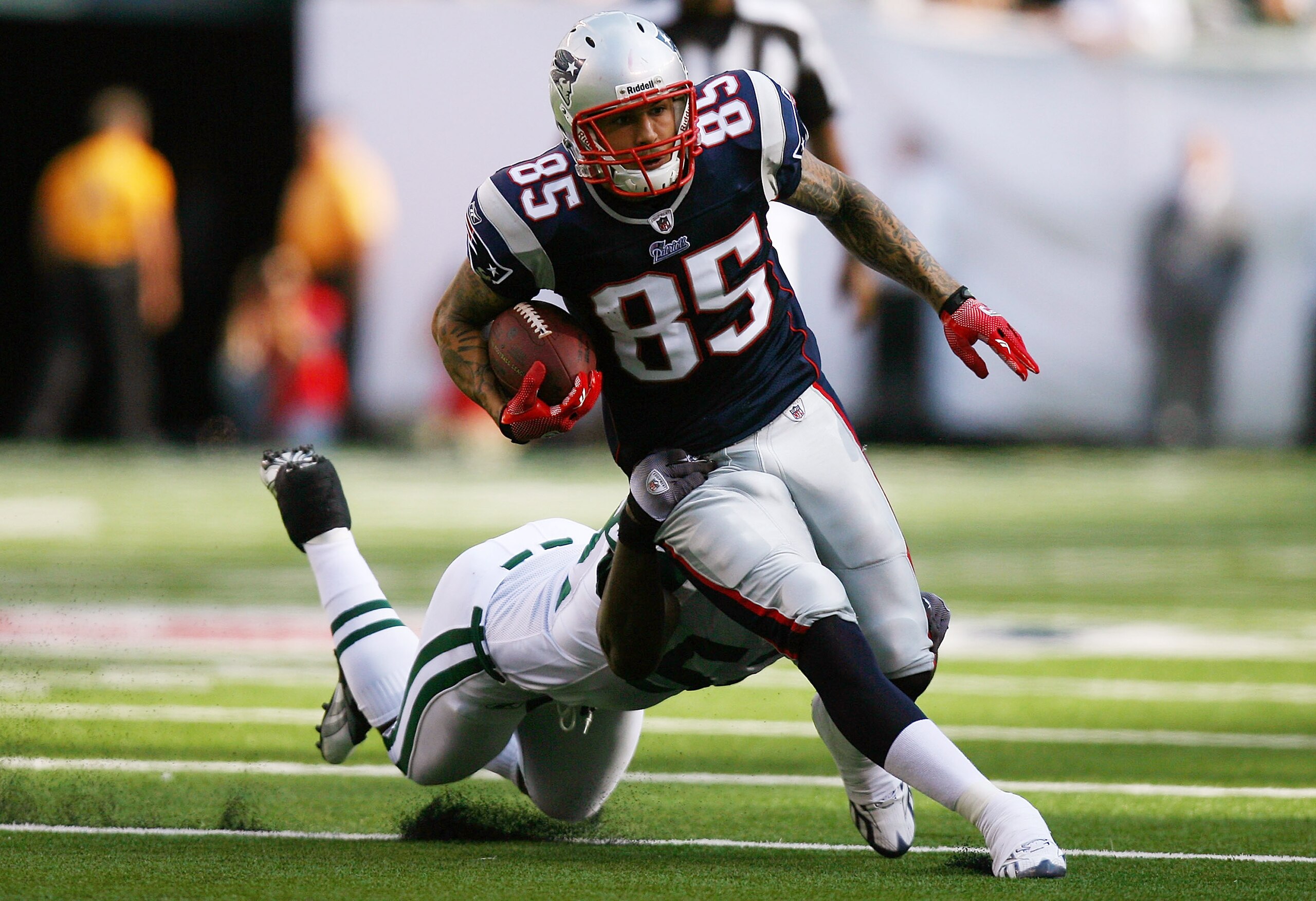 EAST RUTHERFORD, NJ - SEPTEMBER 19: Aaron Hernandez #85 of the New England Patriots runs through a tackle from David Harris #52 of the New York Jets during the first quarter at the New Meadowlands Stadium on September 19, 2010 in East Rutherford, New Jer EAST RUTHERFORD, NJ - SEPTEMBER 19: Aaron Hernandez #85 of the New England Patriots runs through a tackle from David Harris #52 of the New York Jets during the first quarter at the New Meadowlands Stadium on September 19, 2010 in East Rutherford, New Jer