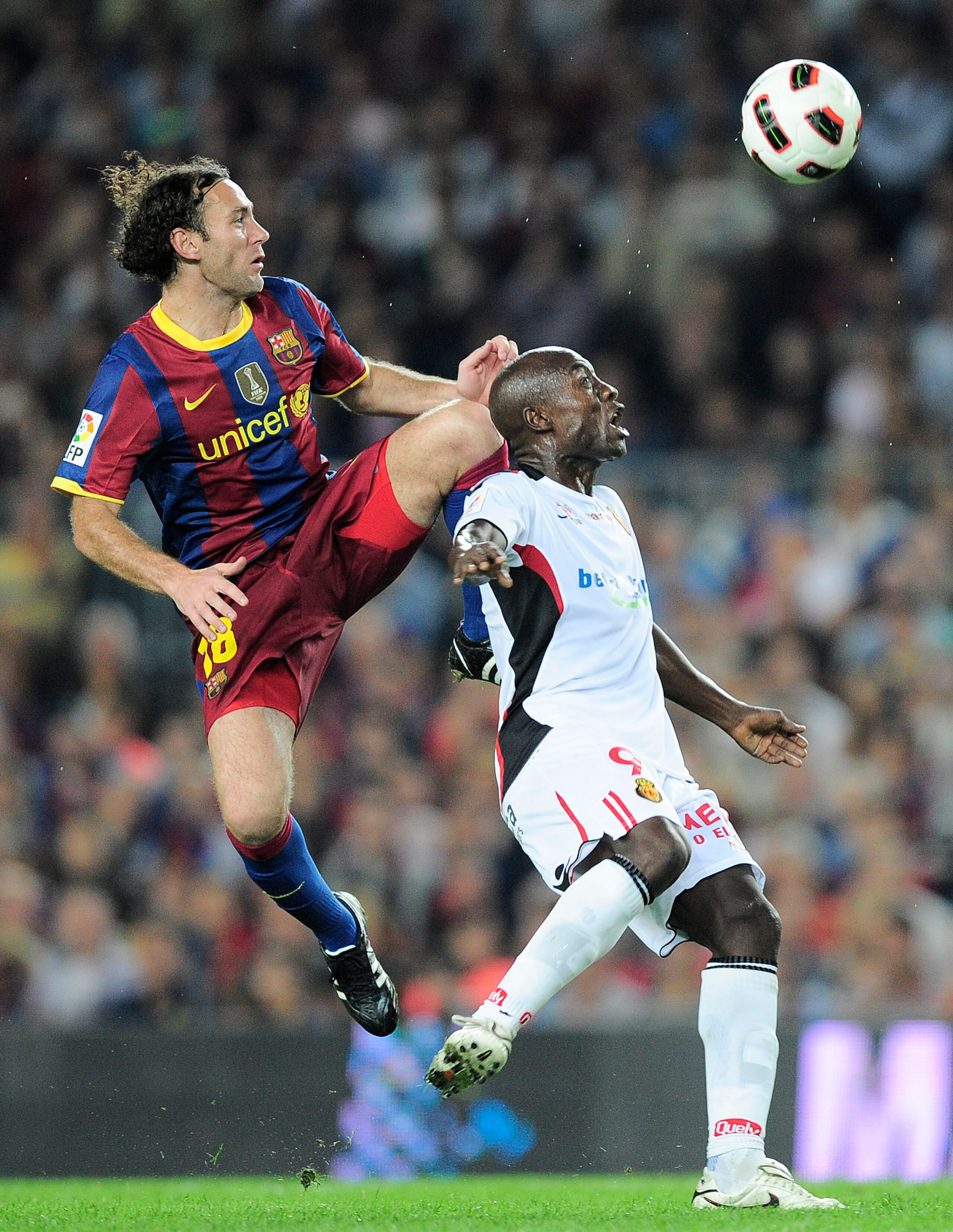 BARCELONA, SPAIN - OCTOBER 03:  Gabriel Milito of Barcelona (L) duels for a high ball with Pierre Webo of Mallorca reacts during the La Liga match between Barcelona and Mallorca at the Camp Nou stadium on October 3, 2010 in Barcelona, Spain. The match end