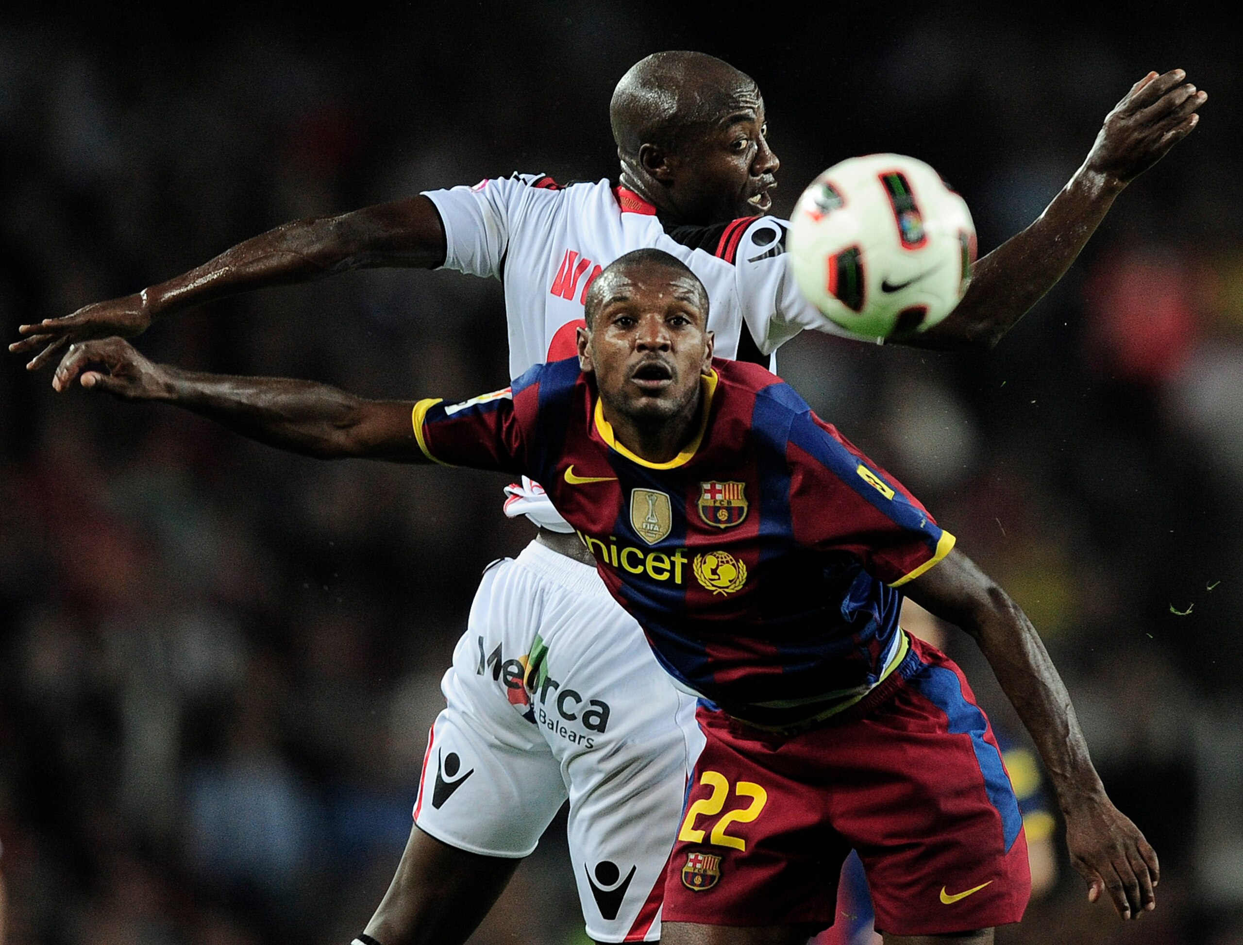 BARCELONA, SPAIN - OCTOBER 03:  Eric Abidal (L) of Barcelona duels for a high ball with Pierre Webo of Mallorca during the La Liga match between Barcelona and Mallorca at the Camp Nou stadium on October 3, 2010 in Barcelona, Spain. The match ended in a 1-