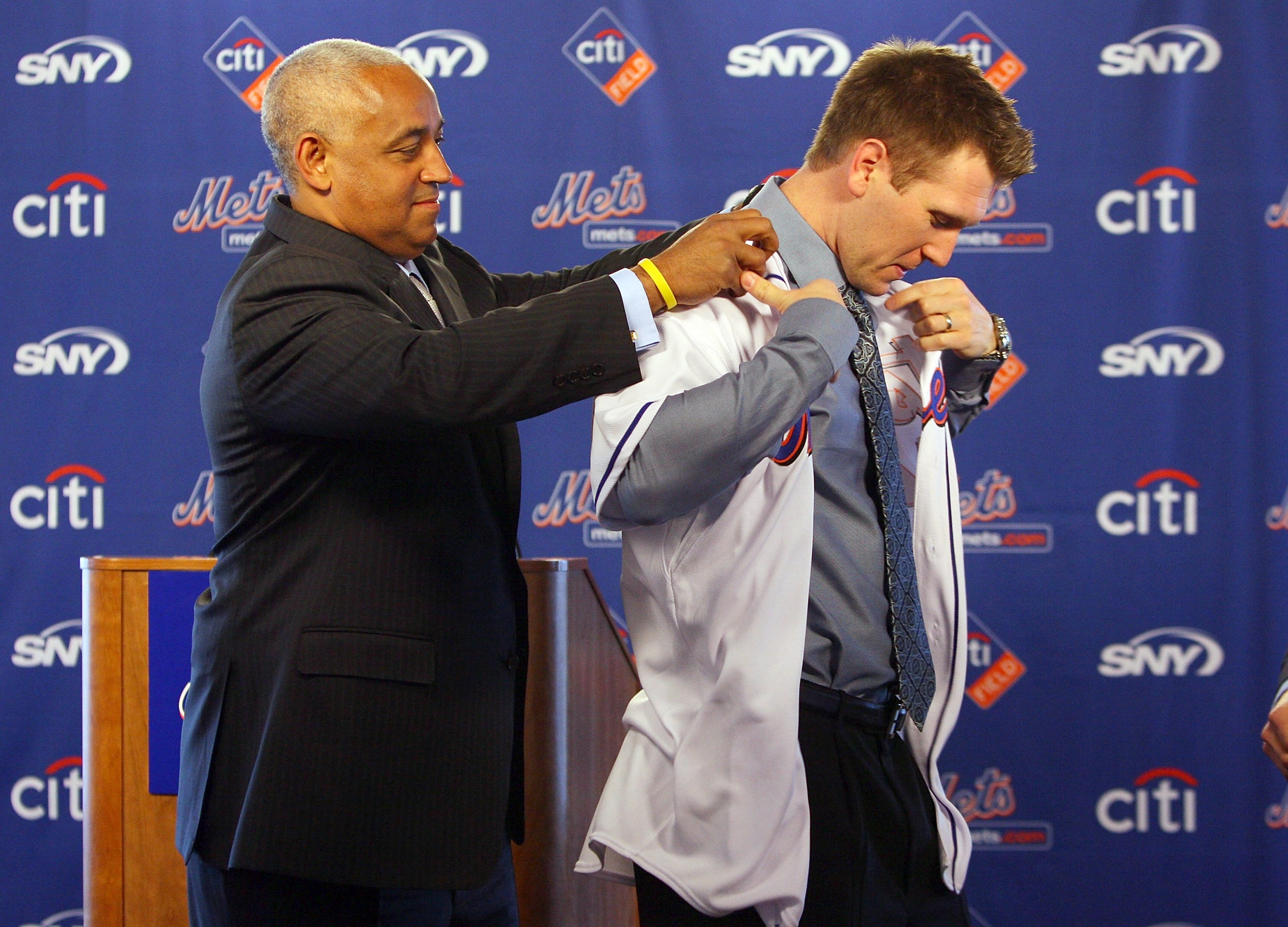 NEW YORK - JANUARY 05: General manager Omar Minaya helps Jason Bay try on his jersey during a press conference to announce Bay's signing to the New York Mets on January 5, 2010 at Citi Field in the Flushing neighborhood of the Queens borough of New York NEW YORK - JANUARY 05: General manager Omar Minaya helps Jason Bay try on his jersey during a press conference to announce Bay's signing to the New York Mets on January 5, 2010 at Citi Field in the Flushing neighborhood of the Queens borough of New York