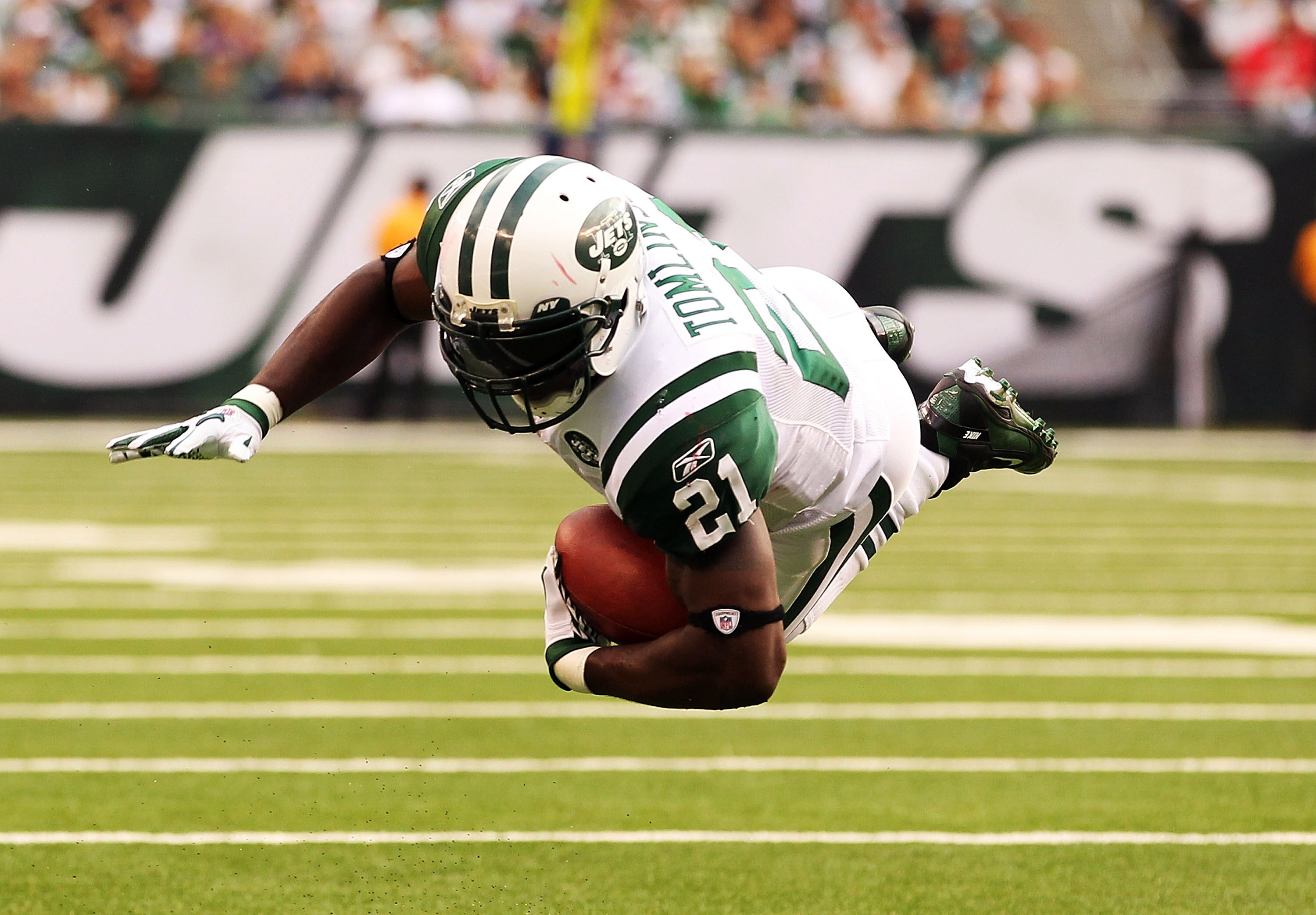 EAST RUTHERFORD, NJ - SEPTEMBER 19:  LaDainian Tomlinson #21  of the New York Jets is tripped up by Devin McCourty #32 of the New England Patriots on September 19, 2010 at the New Meadowlands Stadium  in East Rutherford, New Jersey.  (Photo by Al Bello/Ge