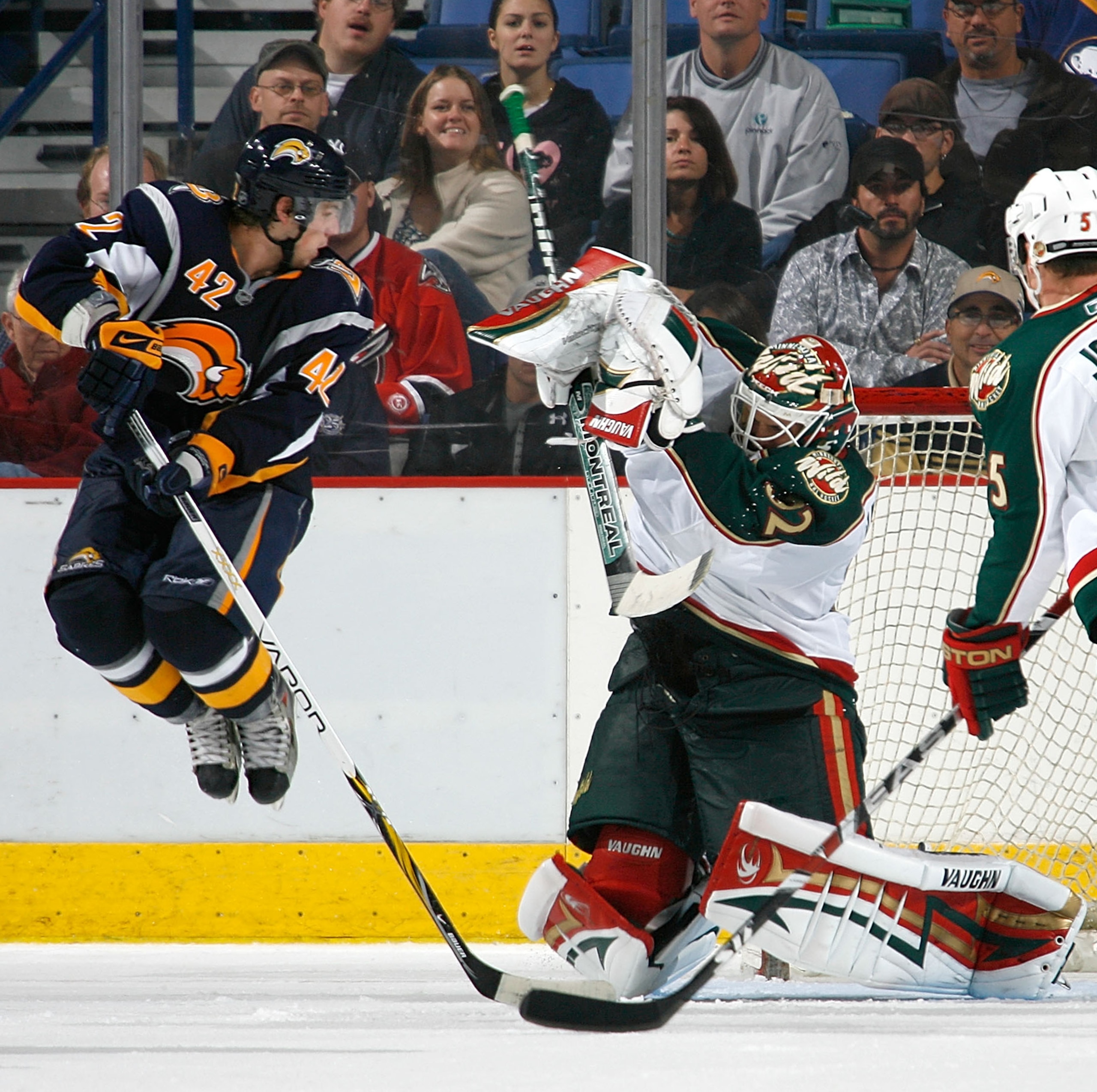 BUFFALO, NY - SEPTEMBER 28: Nathan Gerbe #42 of the Buffalo Sabres jumps to avoid the puck as Niklas Backstrom #32 the Minnesota Wild makes the save with Kim Johnsson #5 watching on September 28, 2008 at HSBC Arena in Buffalo, New York. Minnesota won 2-1
