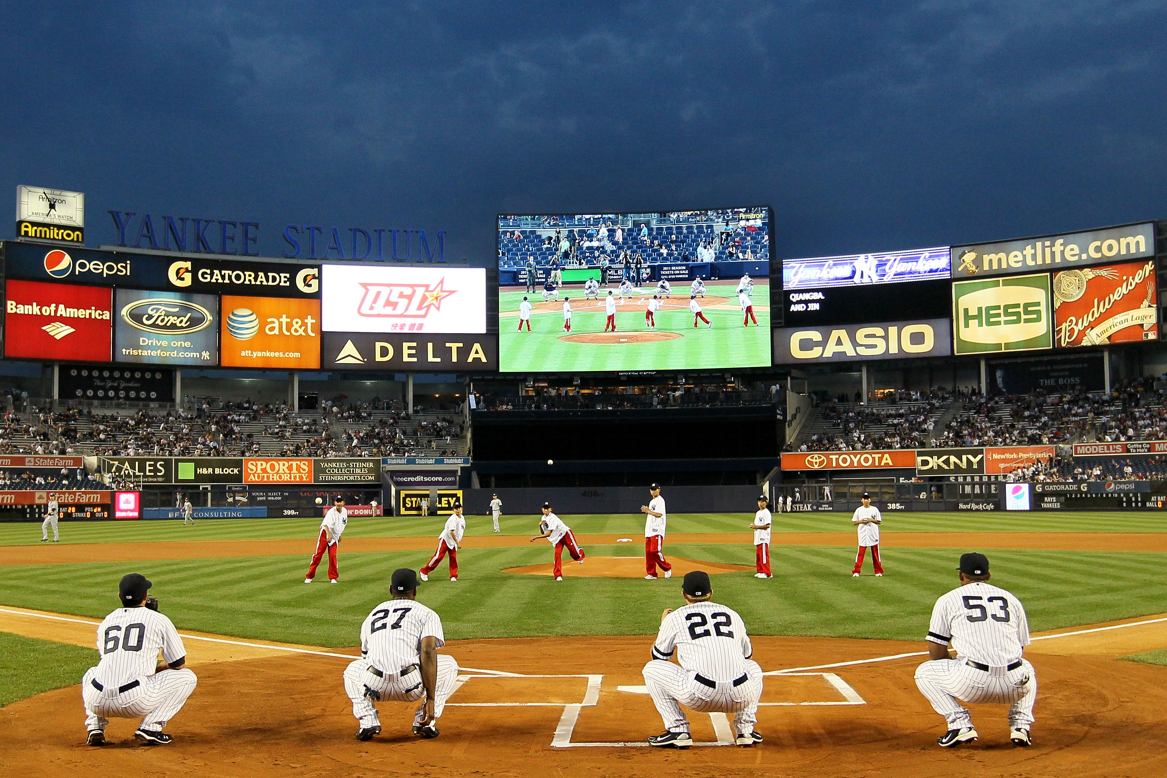 NEW YORK - SEPTEMBER 22: Members of the world championship winning China Youth Baseball League team throw out the first pitch prior to the start of the game between the New York Yankees and the Tampa Bay Rays during their game on September 22, 2010 at Yan NEW YORK - SEPTEMBER 22: Members of the world championship winning China Youth Baseball League team throw out the first pitch prior to the start of the game between the New York Yankees and the Tampa Bay Rays during their game on September 22, 2010 at Yan