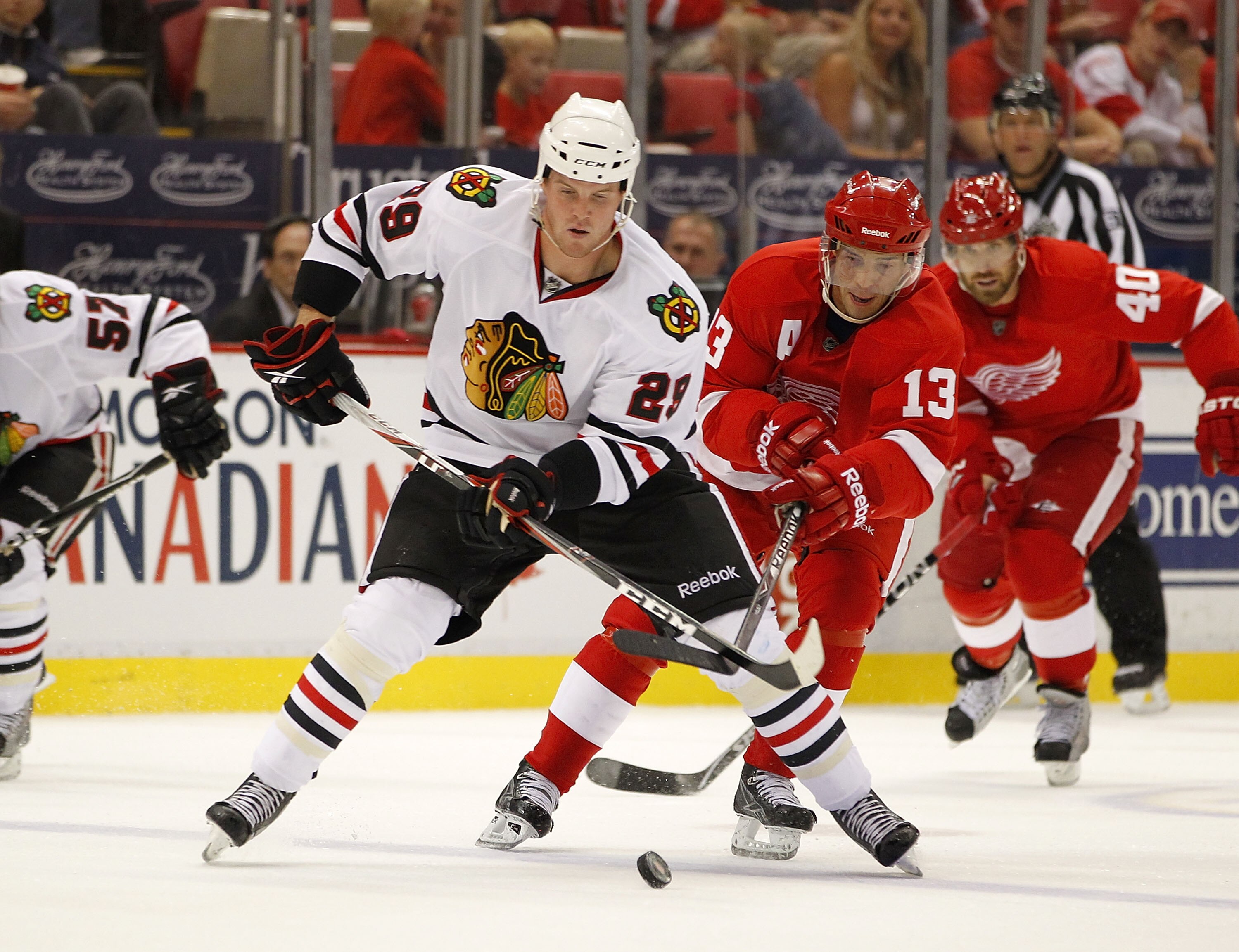 DETROIT - SEPTEMBER 24:  Bryan Bickell #29 of the Chicago Blackhawks tries to control the puck in front of Pavel Datsyuk #13 of the Detroit Red Wings during a pre season game on September 24, 2010 at Joe Louis Arena in Detroit, Michigan.  (Photo by Gregor