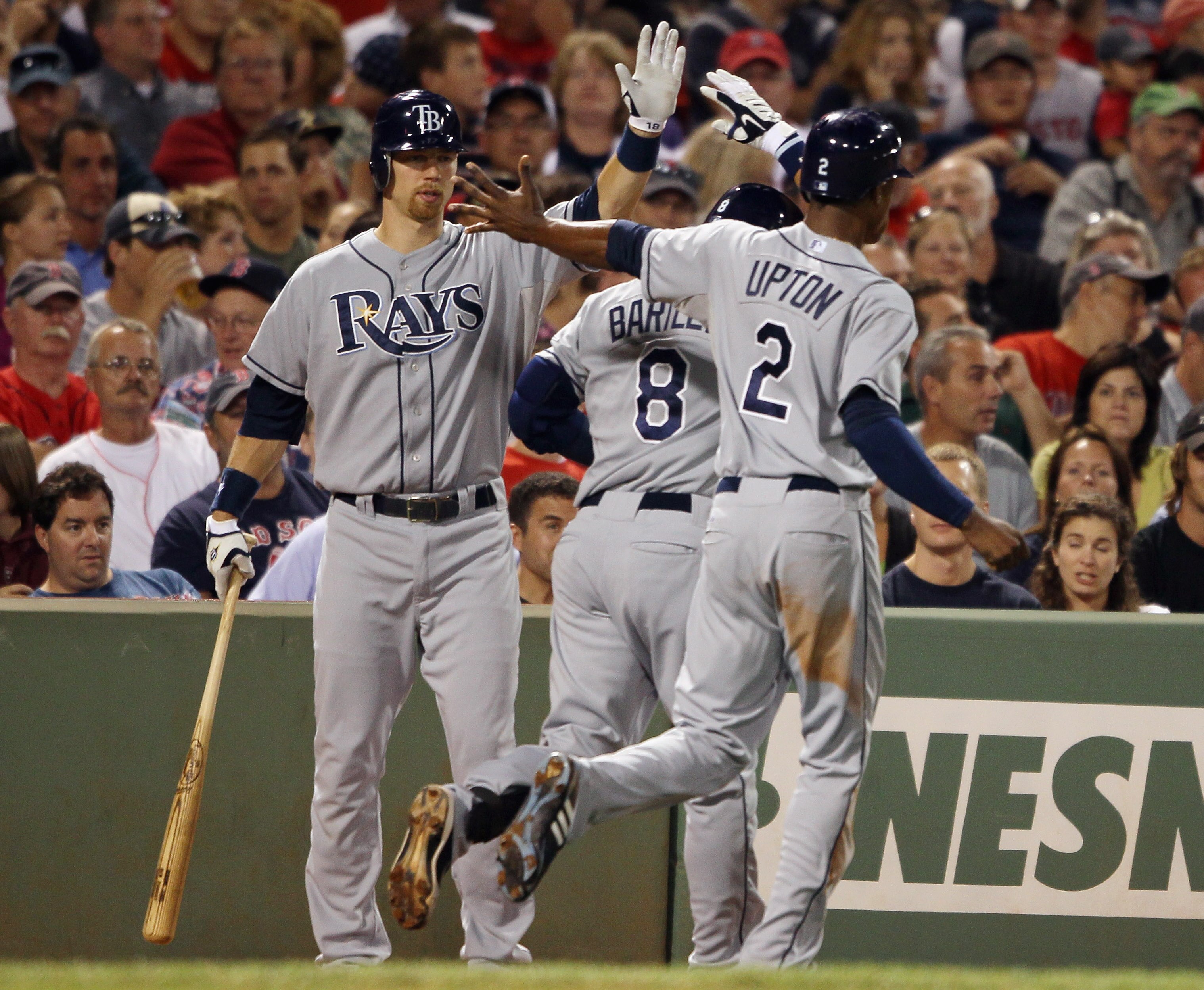 BOSTON - SEPTEMBER 07:  Jason Bartlett #8 and B.J. Upton #2 of the Tampa Bay Rays are congratulated by Ben Zobrist #18 after Bartlett  hit a two run homer in the fifth inning against the Boston Red Sox on September 7, 2010 at Fenway Park in Boston, Massac