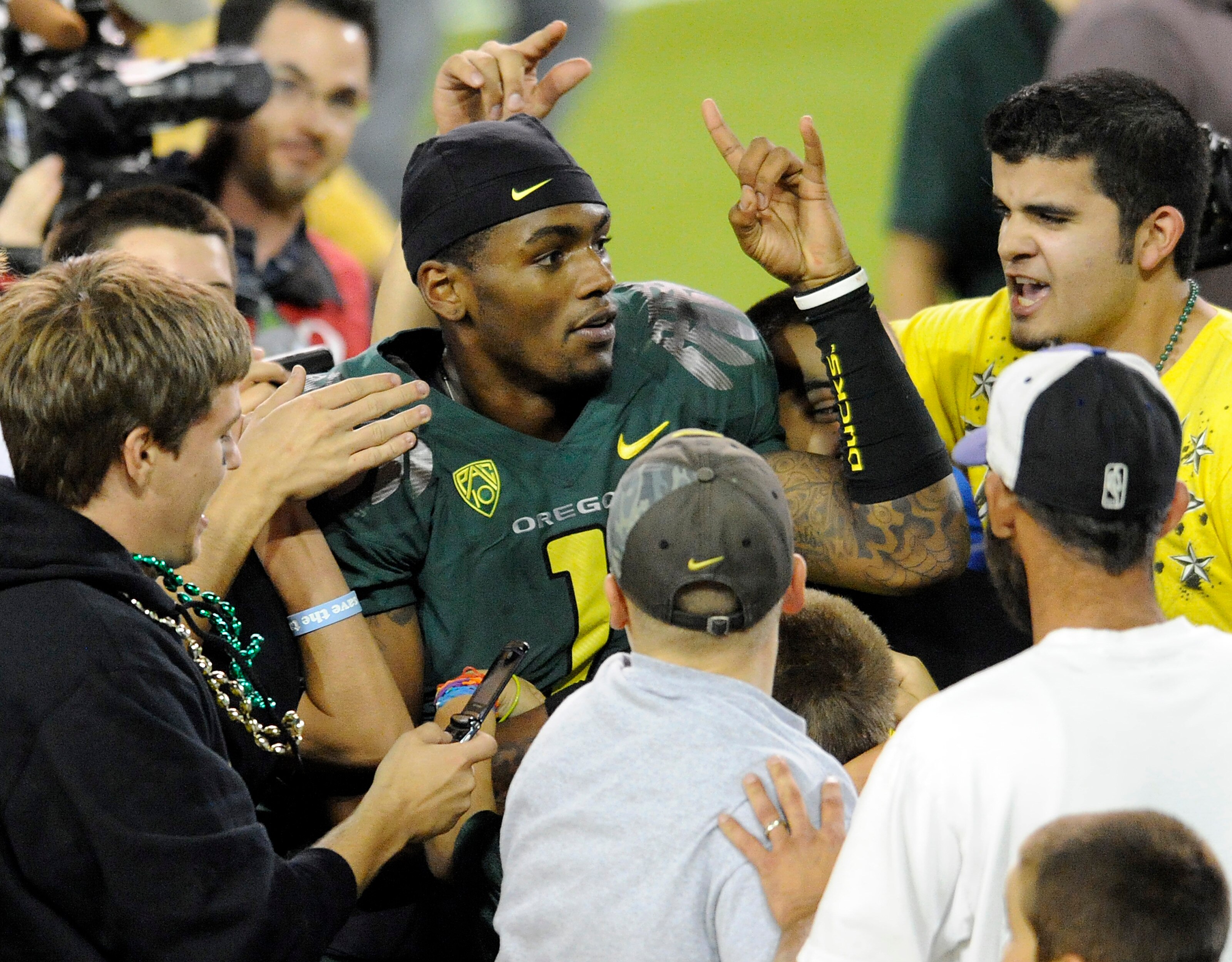 EUGENE, OR - OCTOBER 2: Quarterback Darron Thomas #1 of the Oregon Ducks is mobbed by fans as he runs off the field after the game against the Stanford Cardinal at Autzen Stadium on October 2, 2010 in Eugene, Oregon. Oregon won the game 52-31.(Photo by St