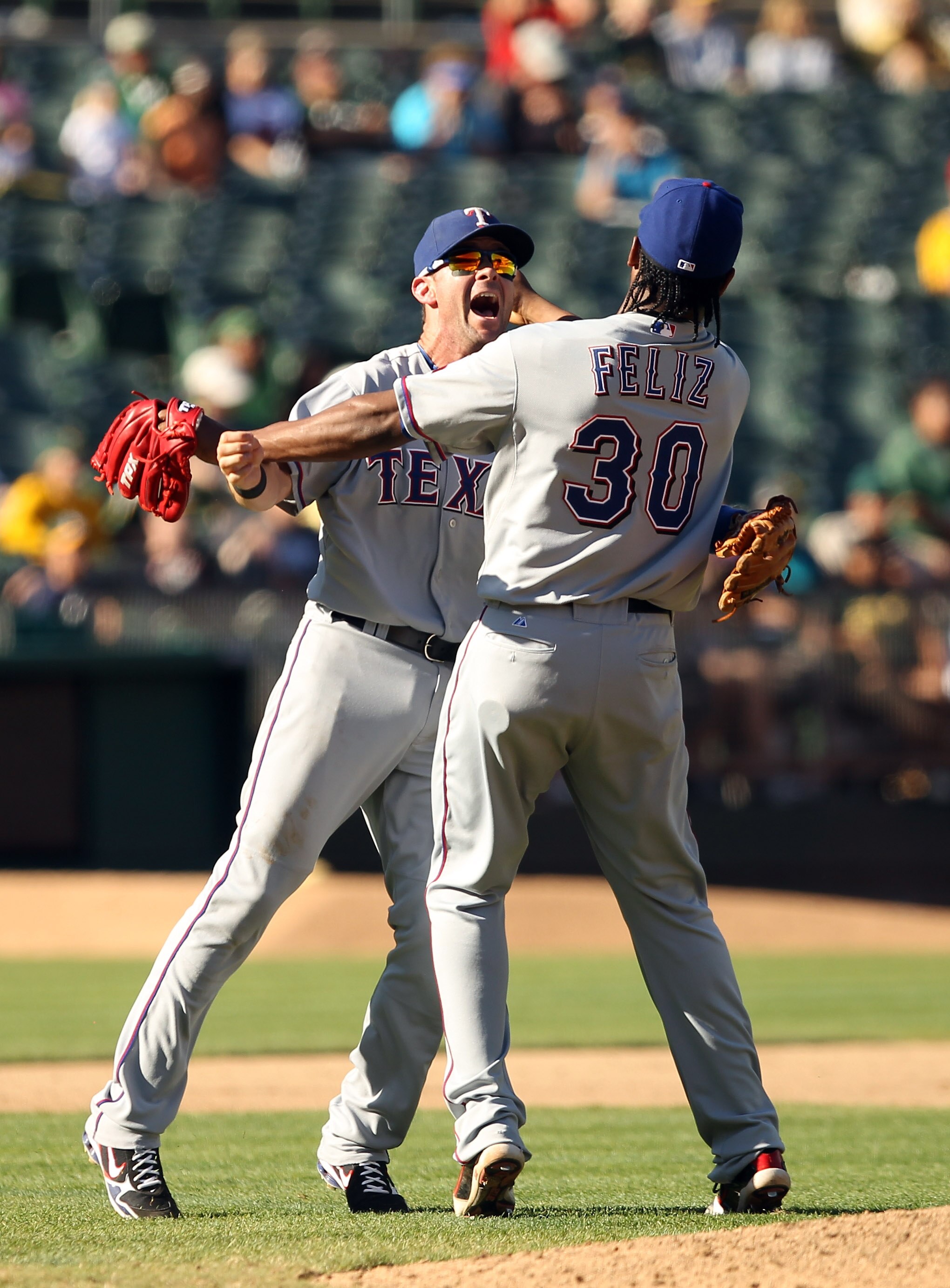 OAKLAND, CA - SEPTEMBER 25:  Michael Young #10 and Neftali Feliz #30 of the Texas Rangers celebrate after they beat the Oakland Athletics to clinch the American League West Title at the Oakland-Alameda County Coliseum on September 25, 2010 in Oakland, Cal