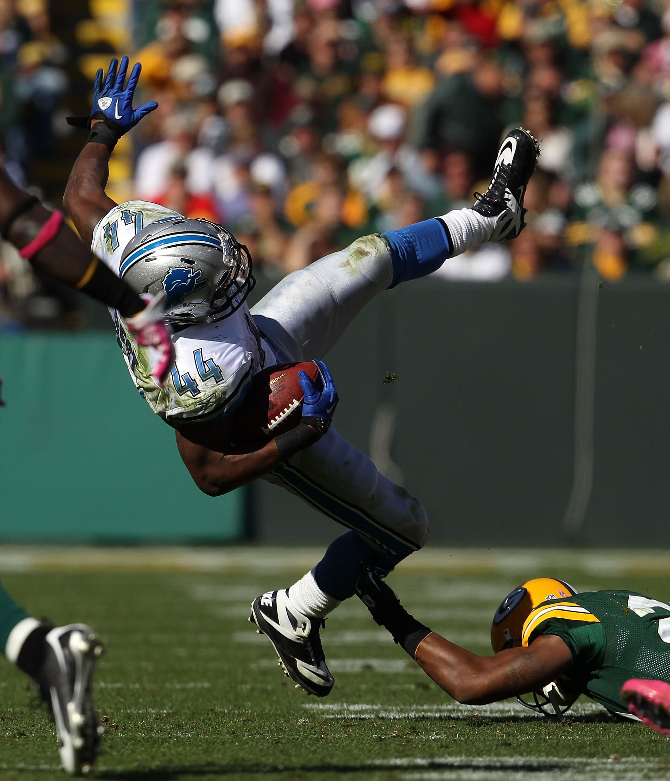GREEN BAY, WI - OCTOBER 03: Rahvid Best #44 of the Detroit Lions is tackled by Charles Woodson #21 of the Green Bay Packers at Lambeau Field on October 3, 2010 in Green Bay, Wisconsin. The Packers defeated the Lions 28-26. (Photo by Jonathan Daniel/Getty