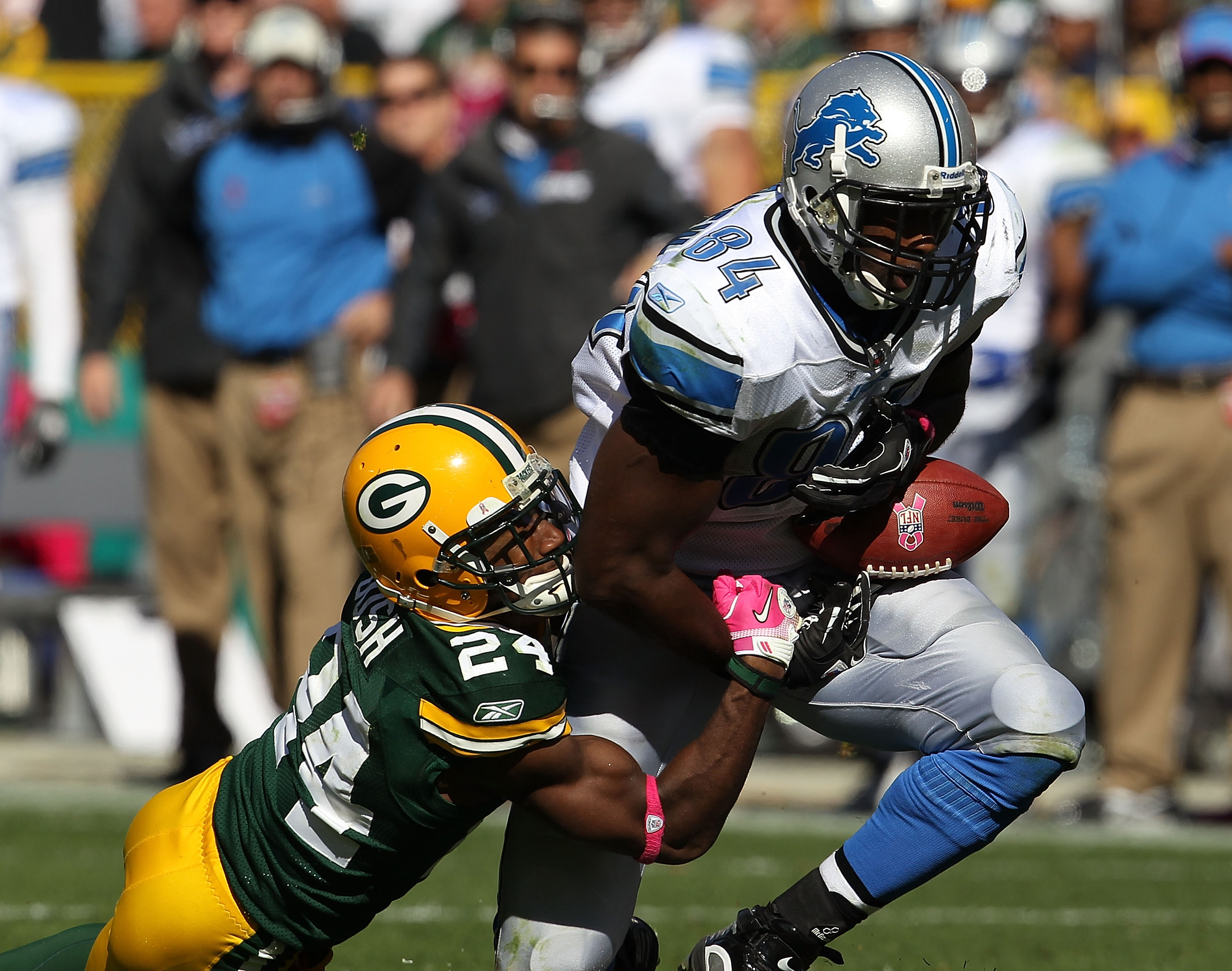 GREEN BAY, WI - OCTOBER 03: Brandon Pettigrew #84 of the Detroit Lions drops a pass as he is hit by Jarrett Bush #24 of the Green Bay Packers at Lambeau Field on October 3, 2010 in Green Bay, Wisconsin. The Packers defeated the Lions 28-26.  (Photo by Jon