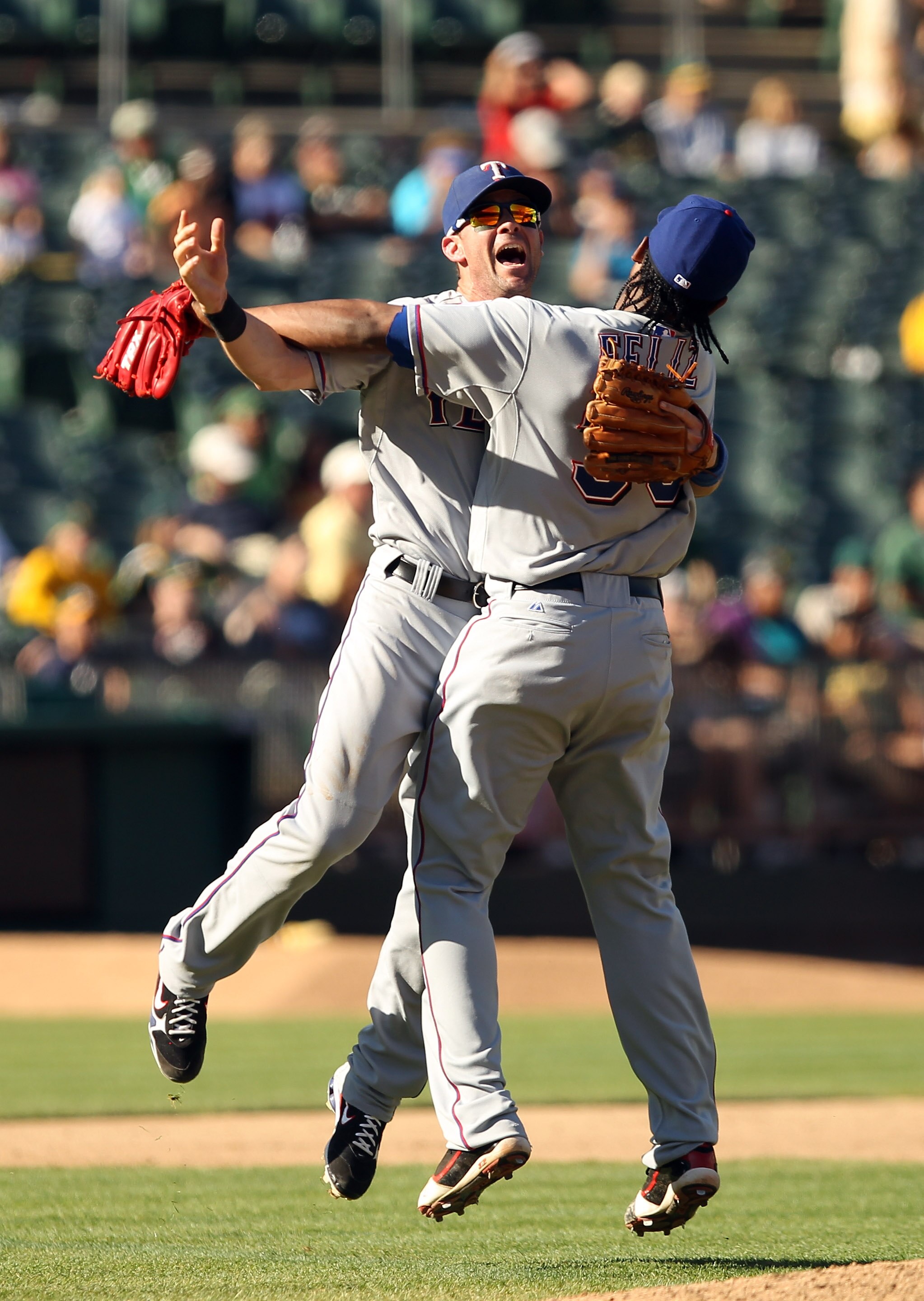 OAKLAND, CA - SEPTEMBER 25:  Michael Young #10 and Neftali Feliz #30 of the Texas Rangers celebrate after they beat the Oakland Athletics to clinch the American League West Title at the Oakland-Alameda County Coliseum on September 25, 2010 in Oakland, Cal