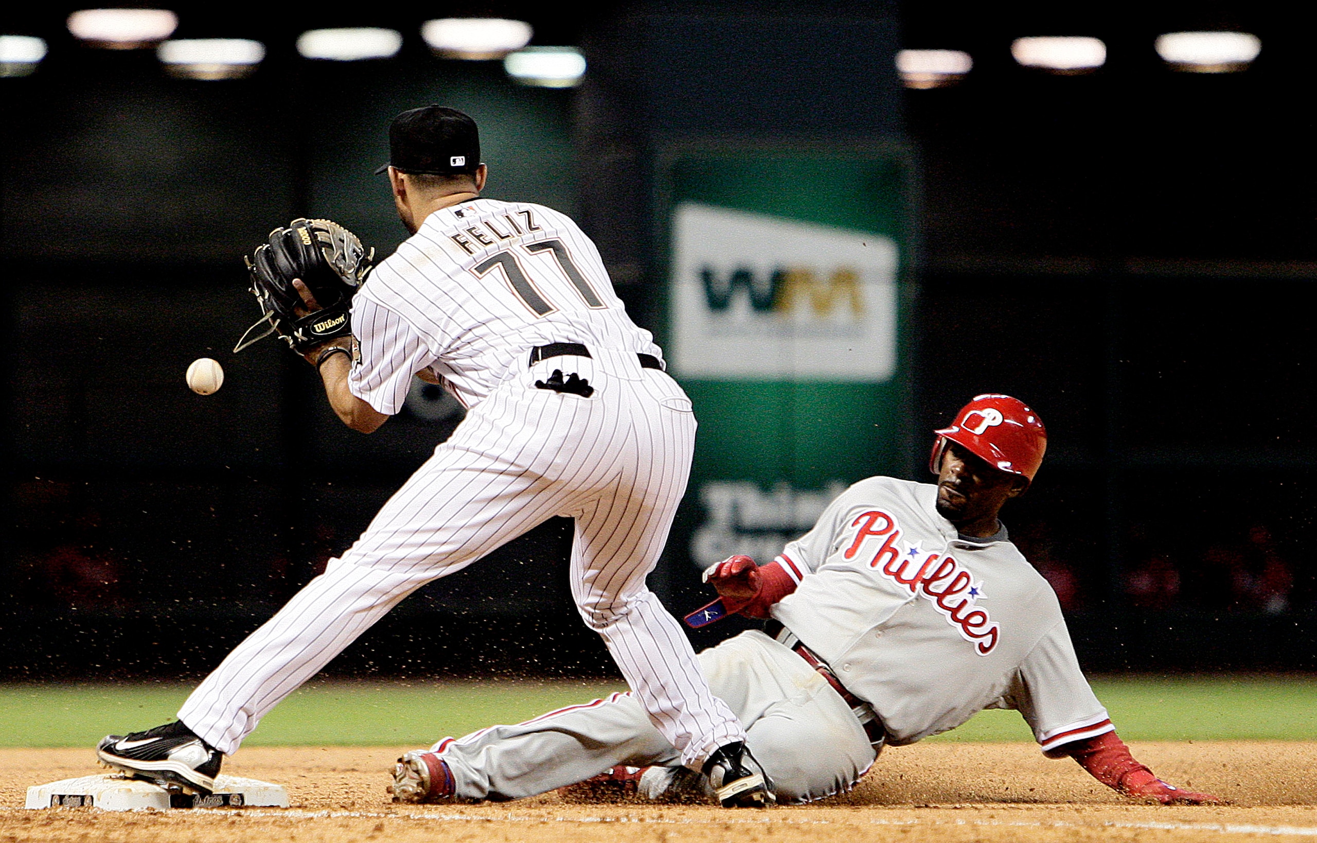 HOUSTON - APRIL 09: Jimmy Rollins #11 of the Philadelphia Phillies slides safely into third base in the seventh inning as third baseman Pedro Feliz #77 of the Houston Astros awaits the throw at Minute Maid Park on April 9, 2010 in Houston, Texas. (Photo HOUSTON - APRIL 09: Jimmy Rollins #11 of the Philadelphia Phillies slides safely into third base in the seventh inning as third baseman Pedro Feliz #77 of the Houston Astros awaits the throw at Minute Maid Park on April 9, 2010 in Houston, Texas. (Photo