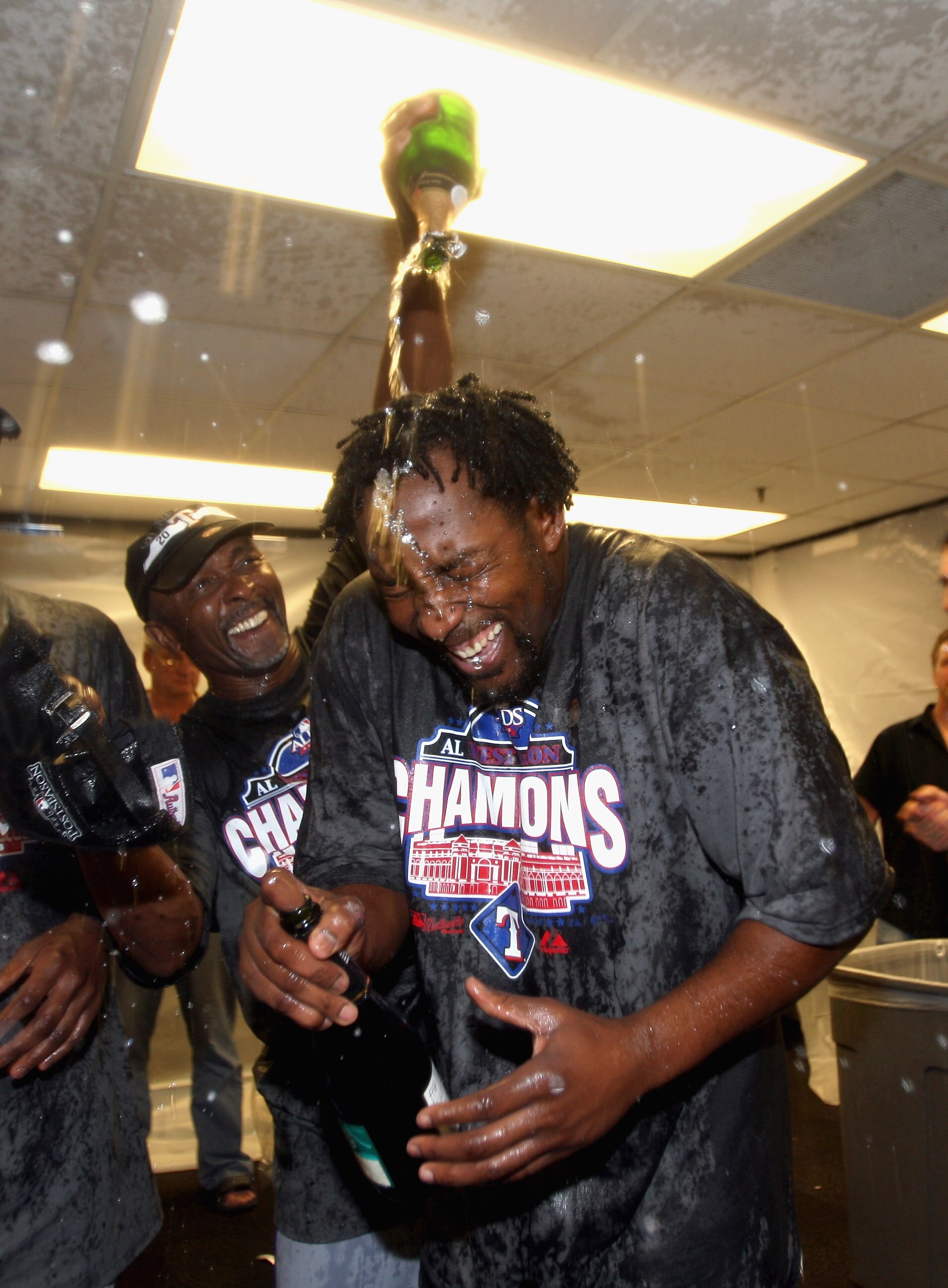 OAKLAND, CA - SEPTEMBER 25:  Vladimir Guerrero #27 of the Texas Rangers is covered in champagne by Gary Pettis after they beat the Oakland Athletics to clinch the American League West Title at the Oakland-Alameda County Coliseum on September 25, 2010 in O