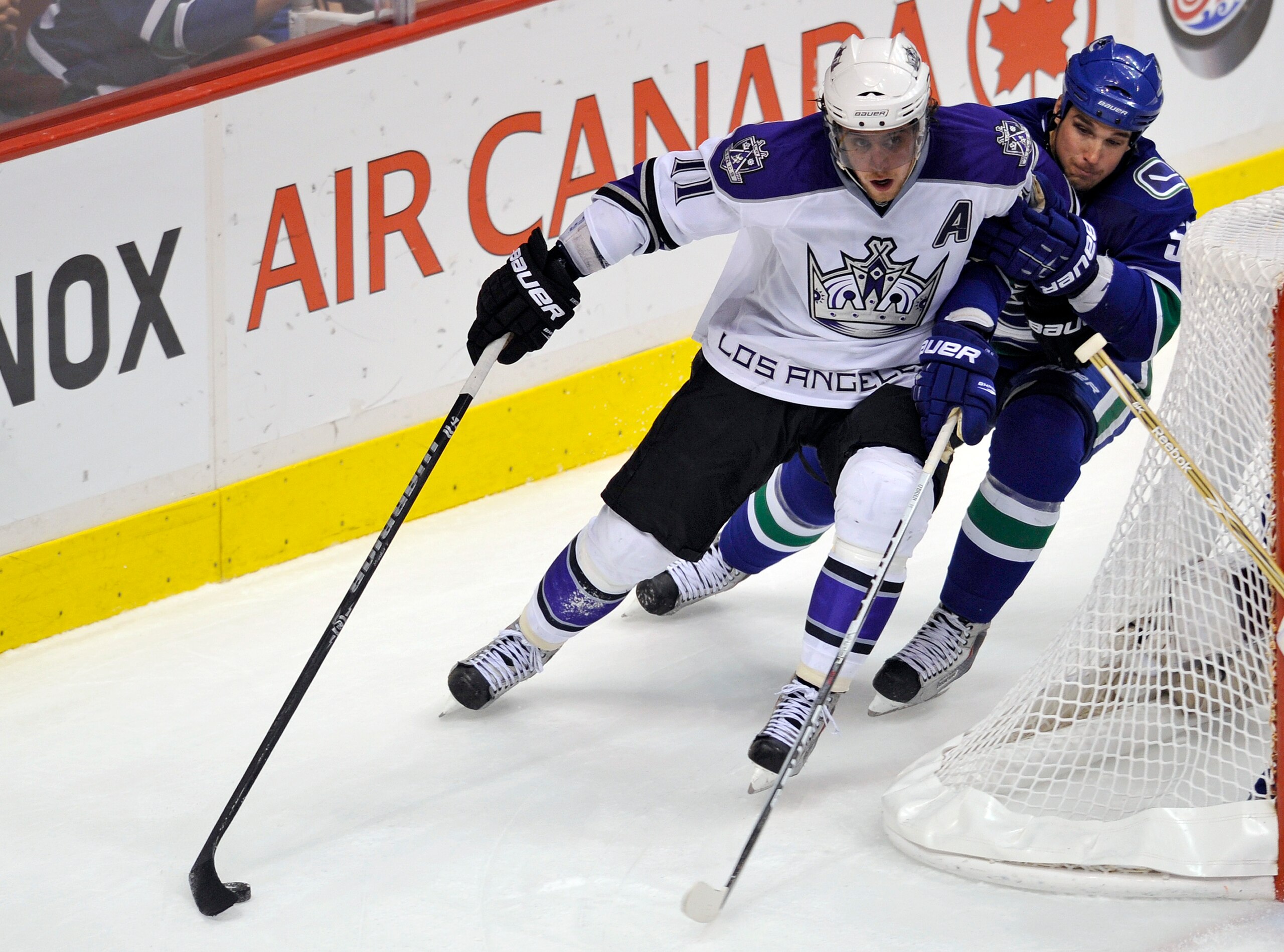 VANCOUVER, CANADA - APRIL 23:  Anze Kopitar #11 of the Los Angeles Kings tries for a wrap-around while being checked by Shane O'Brien #55 of the Vancouver Canucks during the second period in Game Five of the Western Conference Quarterfinals during the 201