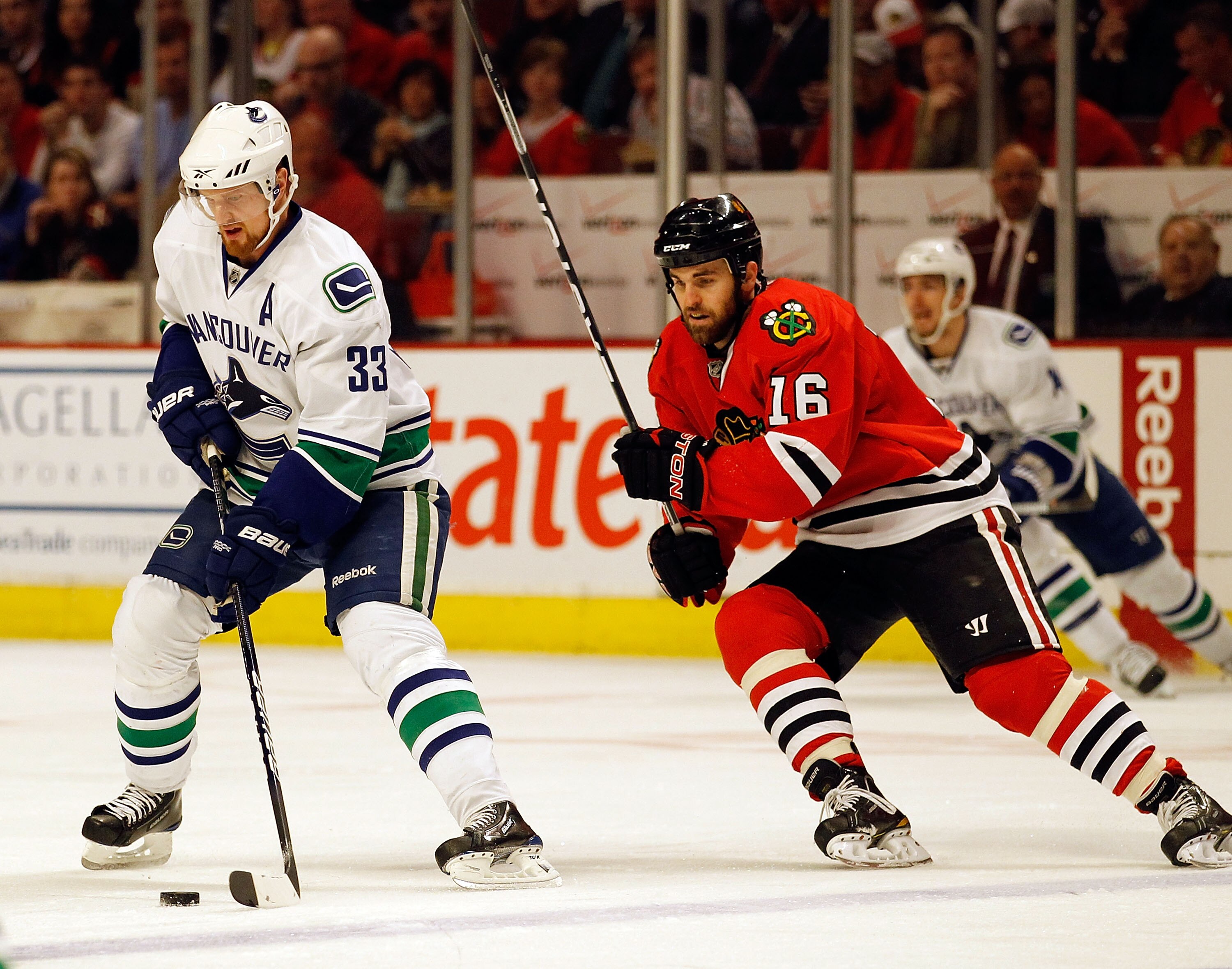 CHICAGO - MAY 09: Henrik Sedin #33 of the Vancouver Canucks moves across the ice with the puck as Andrew Ladd #16 of the Chicago Blackhawks closes in in Game Five of the Western Conference Semifinals during the 2010 NHL Stanley Cup Playoffs at United Cent