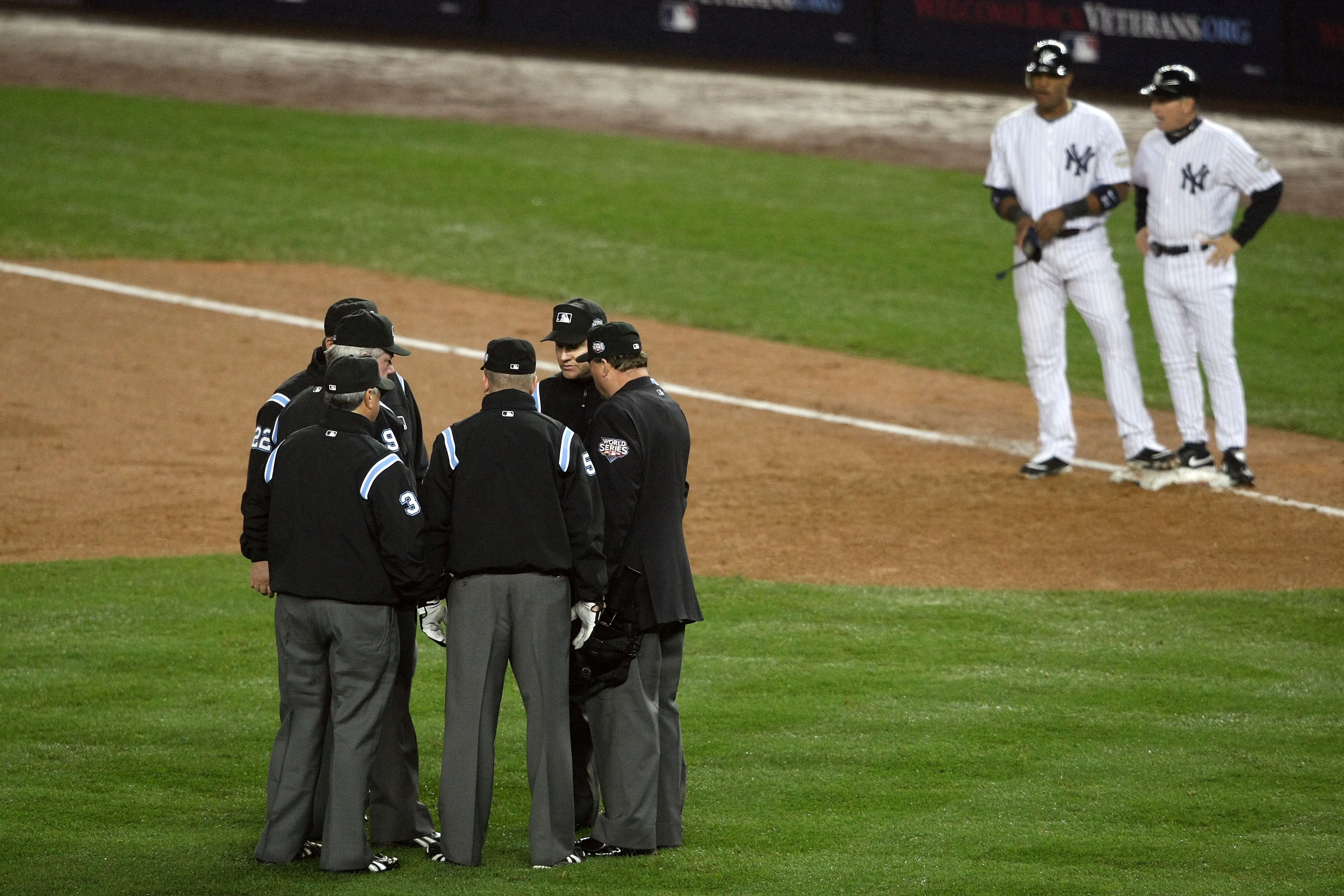NEW YORK - OCTOBER 28:  The umpire crew huddles for a conference as the New York Yankees bat against the Philadelphia Phillies in Game One of the 2009 MLB World Series at Yankee Stadium on October 28, 2009 in the Bronx borough of New York City.  (Photo by