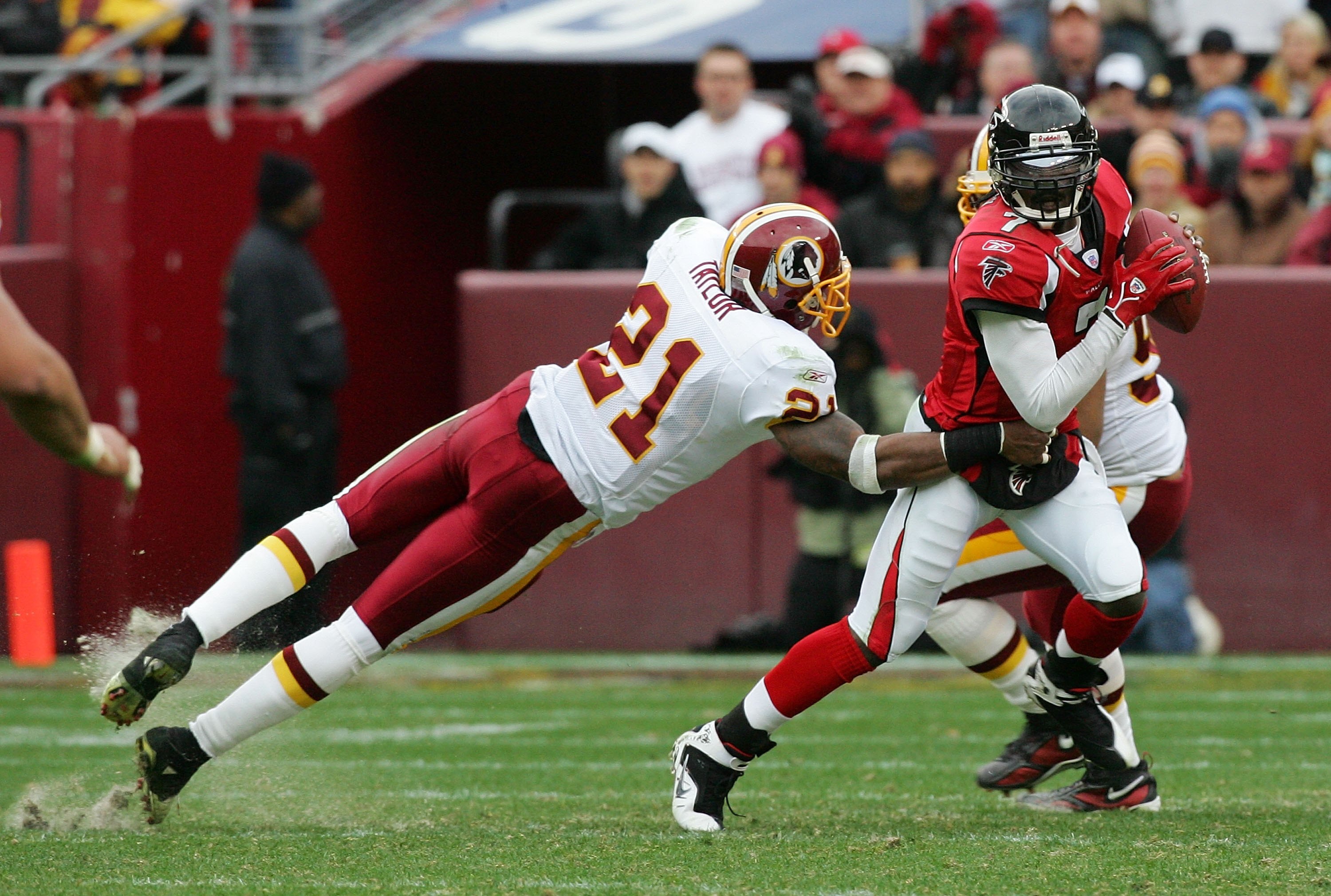 LANDOVER, MD - DECEMBER 03:   Michael Vick #7 of the Atlanta Falcons avoids a tackle from Sean Taylor #21 of the Washington Redskins December 3, 2006 at FedEx Field in Landover, Maryland.The Falcons defeated the Redskins, 24-14.  (Photo by Jim McIsaac/Get
