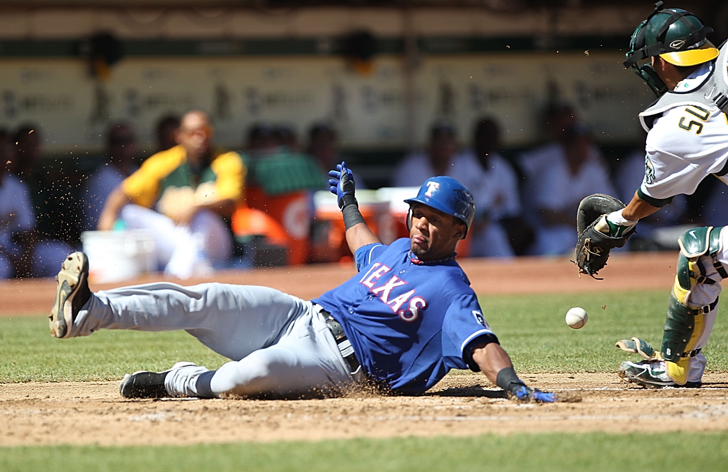 OAKLAND, CA - SEPTEMBER 26:  Kurt Suzuki #8 of the Oakland Athletics fails to tag out Julio Borbon #29 of the Texas Rangers on a single by David Murphy in the second inning during a Major League Baseball game at the Oakland-Alameda County Coliseum on Sept