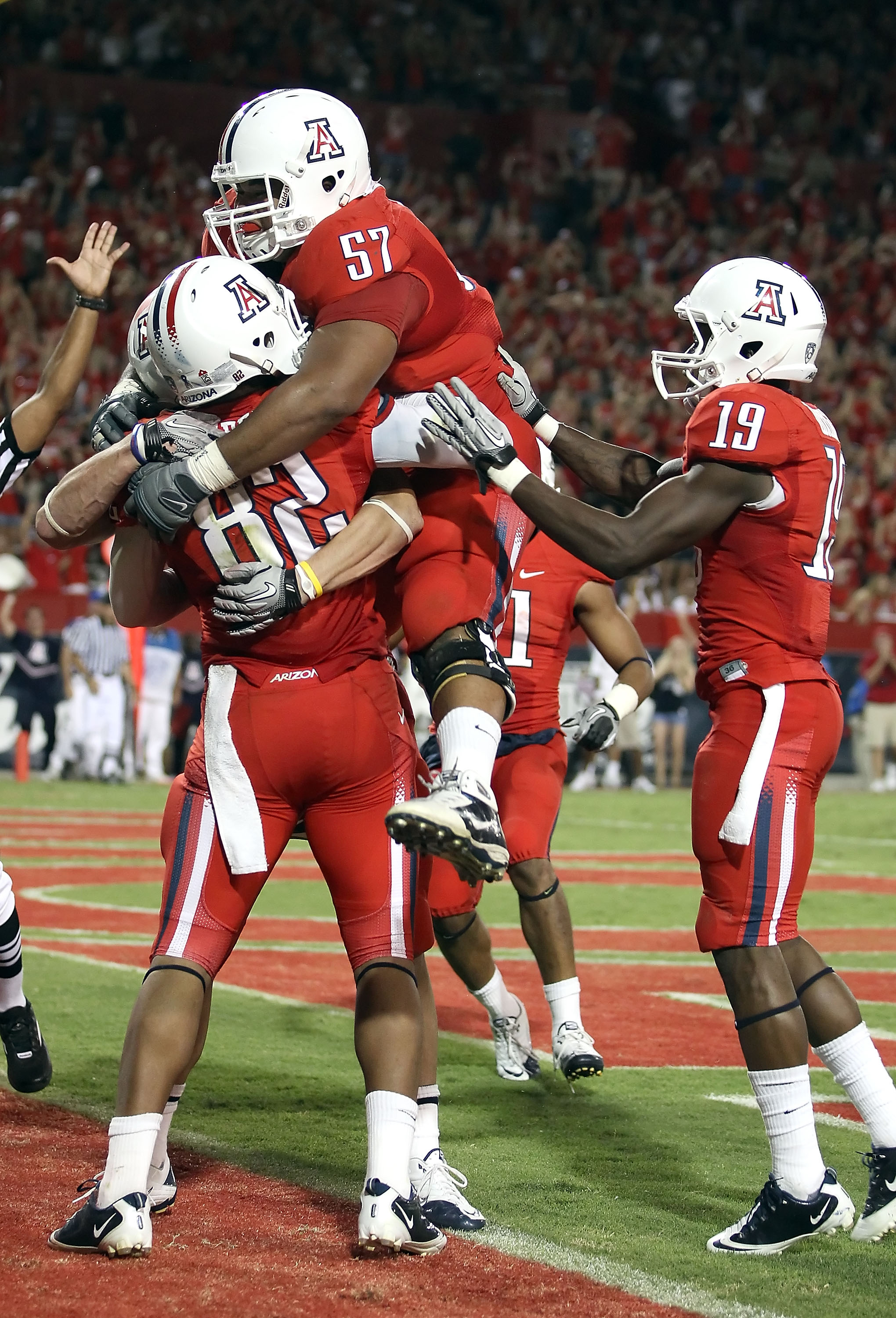 TUCSON, AZ - SEPTEMBER 25:  Jovon Hayes #57 of the Arizona Wildcats jumps into the arms of wide receiver Juron Criner #82 after Criner caught the game winning 3 yard touchdown reception against the California Golden Bears during the fourth quarter of the