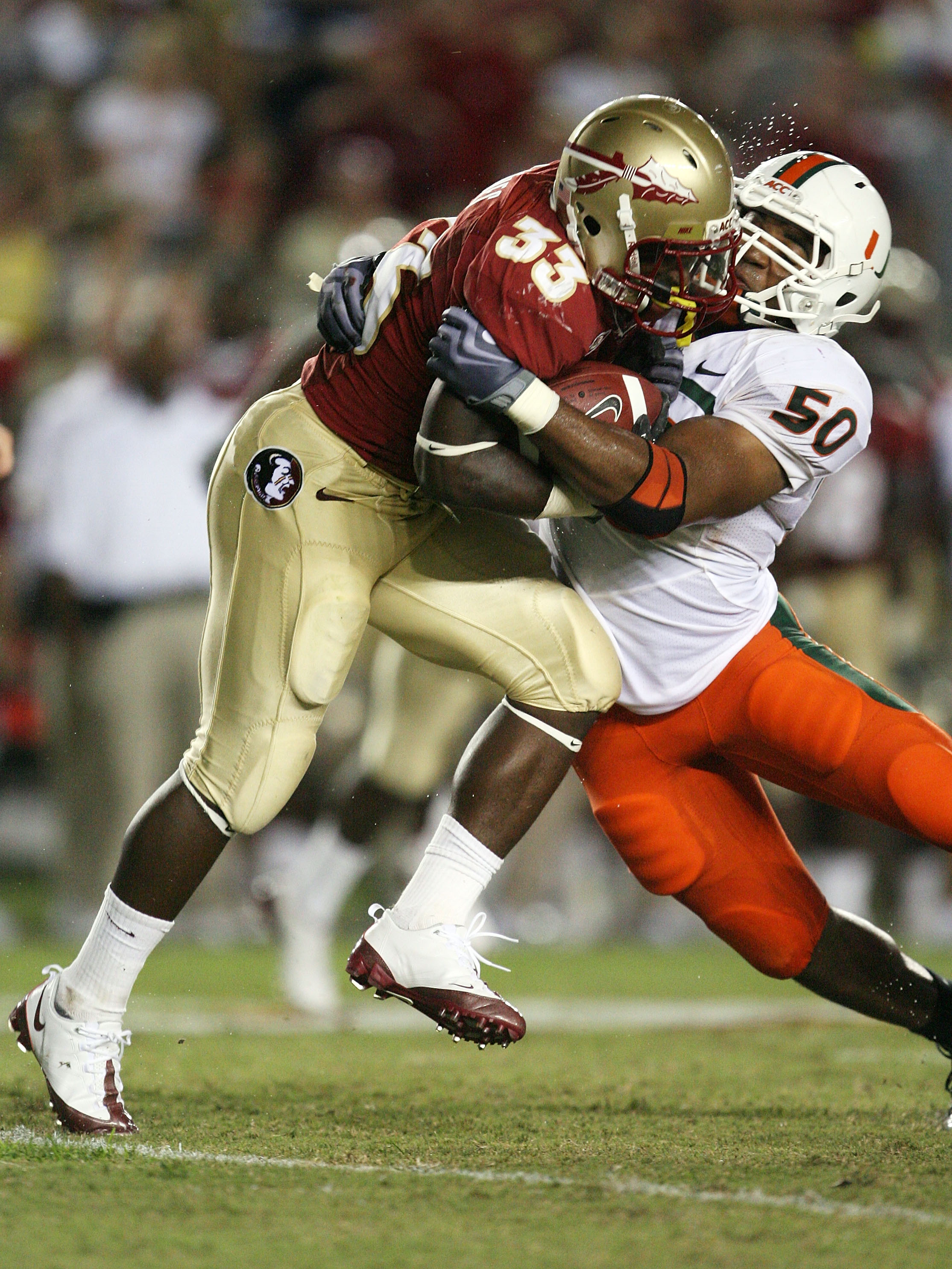 TALLAHASSEE, FL - SEPTEMBER 07:  Linebacker Darryl Sharpton #50 of the Miami Hurricanes brings down running back Ty Jones #33 of the Florida State Seminoles at Doak Campbell Stadium on September 7, 2009 in Tallahassee, Florida. Miami defeated Florida Stat