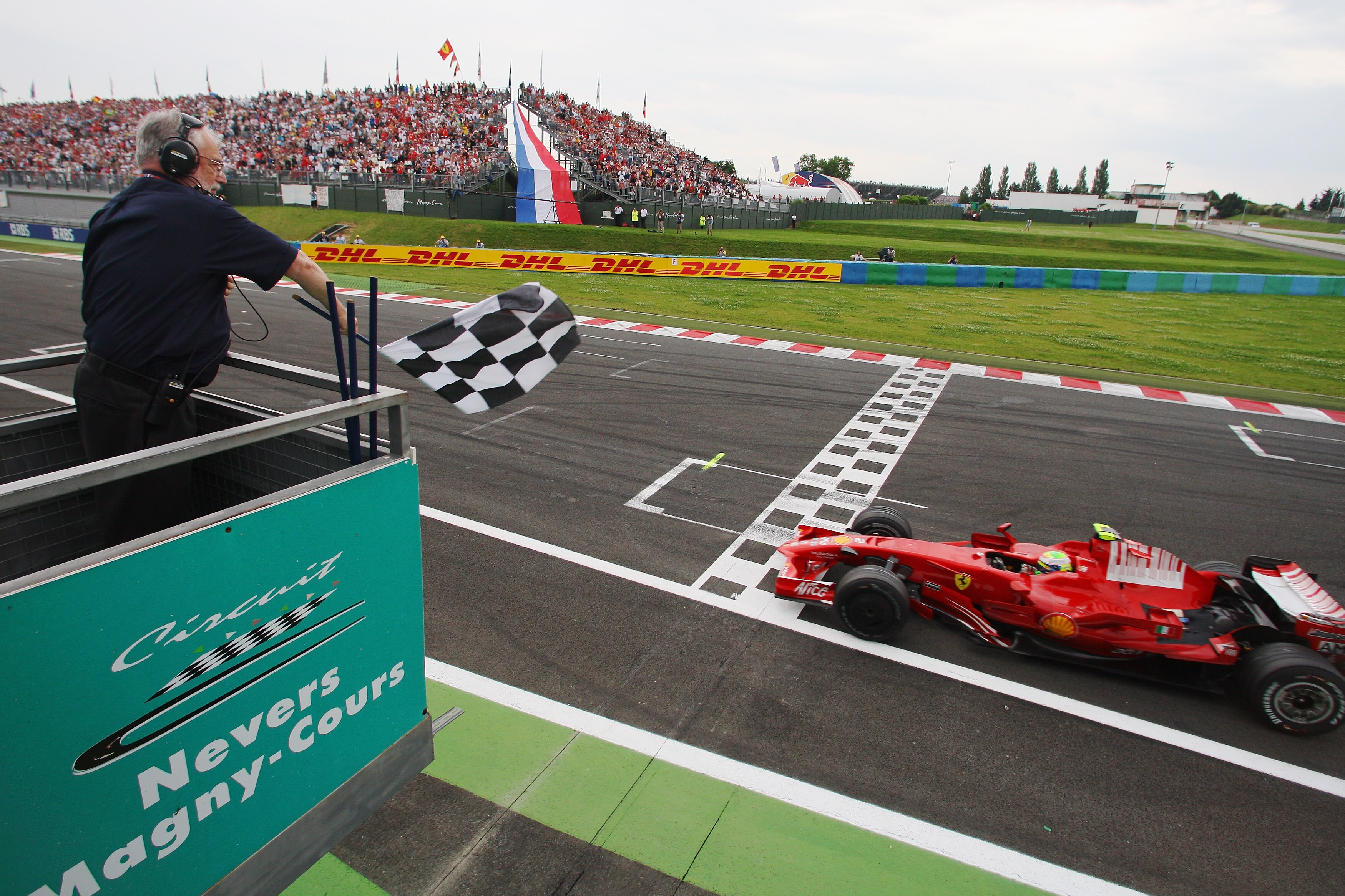 NEVERS, FRANCE - JUNE 22:  Felipe Massa of Brazil and Ferrari crosses the finish line to win the French Formula One Grand Prix at the Circuit de Nevers Magny-Cours on June 22, 2008 in Nevers, France.  (Photo by Mark Thompson/Getty Images)