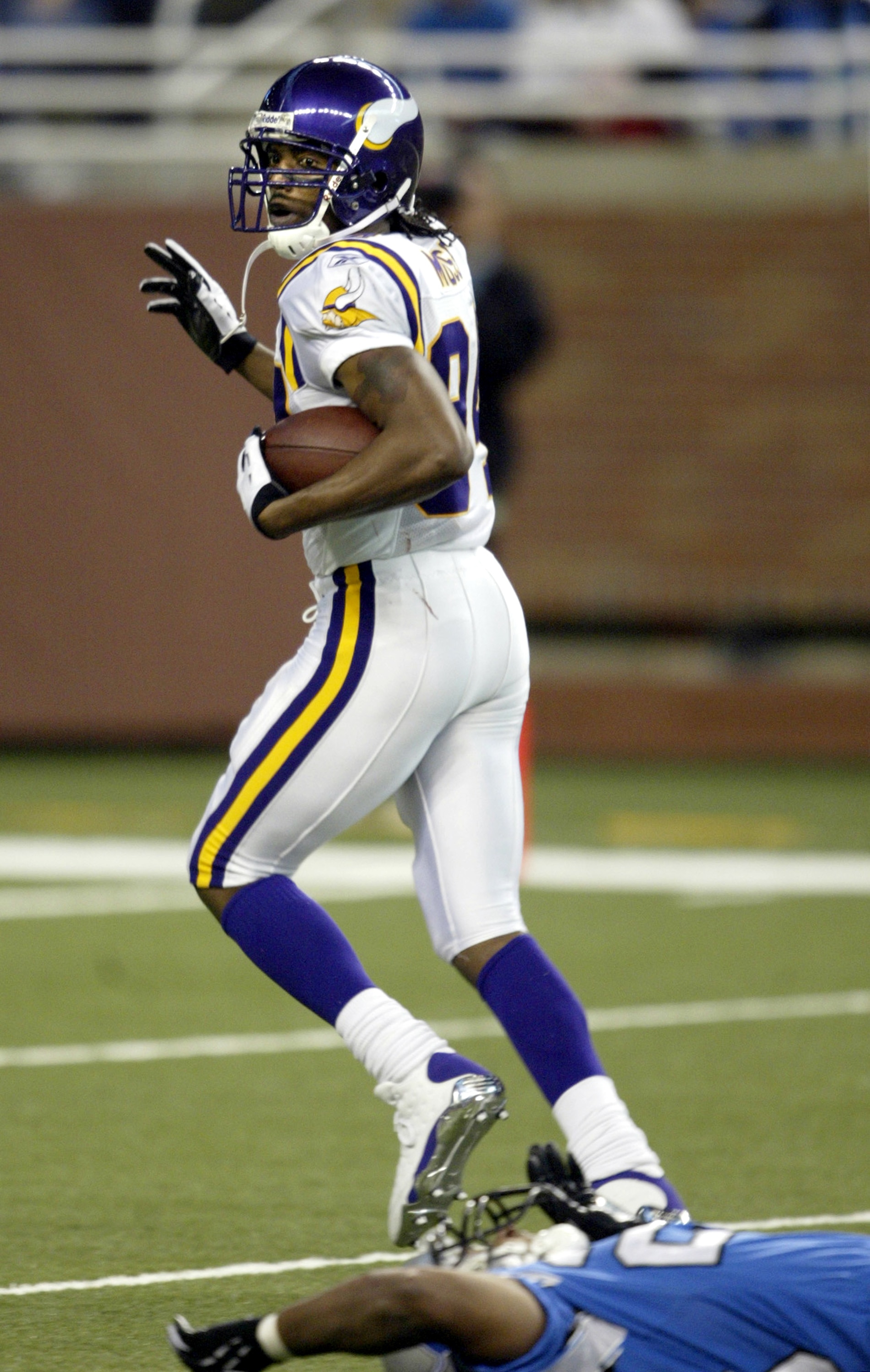 DETROIT - DECEMBER 19: Randy Moss #84 of the Minnesota Vikings looks behind him and runs to the end zone to complete an 82 yard touchdown reception against the Detroit Lions at Ford Field on December 19, 2004 in Detroit, Michigan. The Vikings won the game