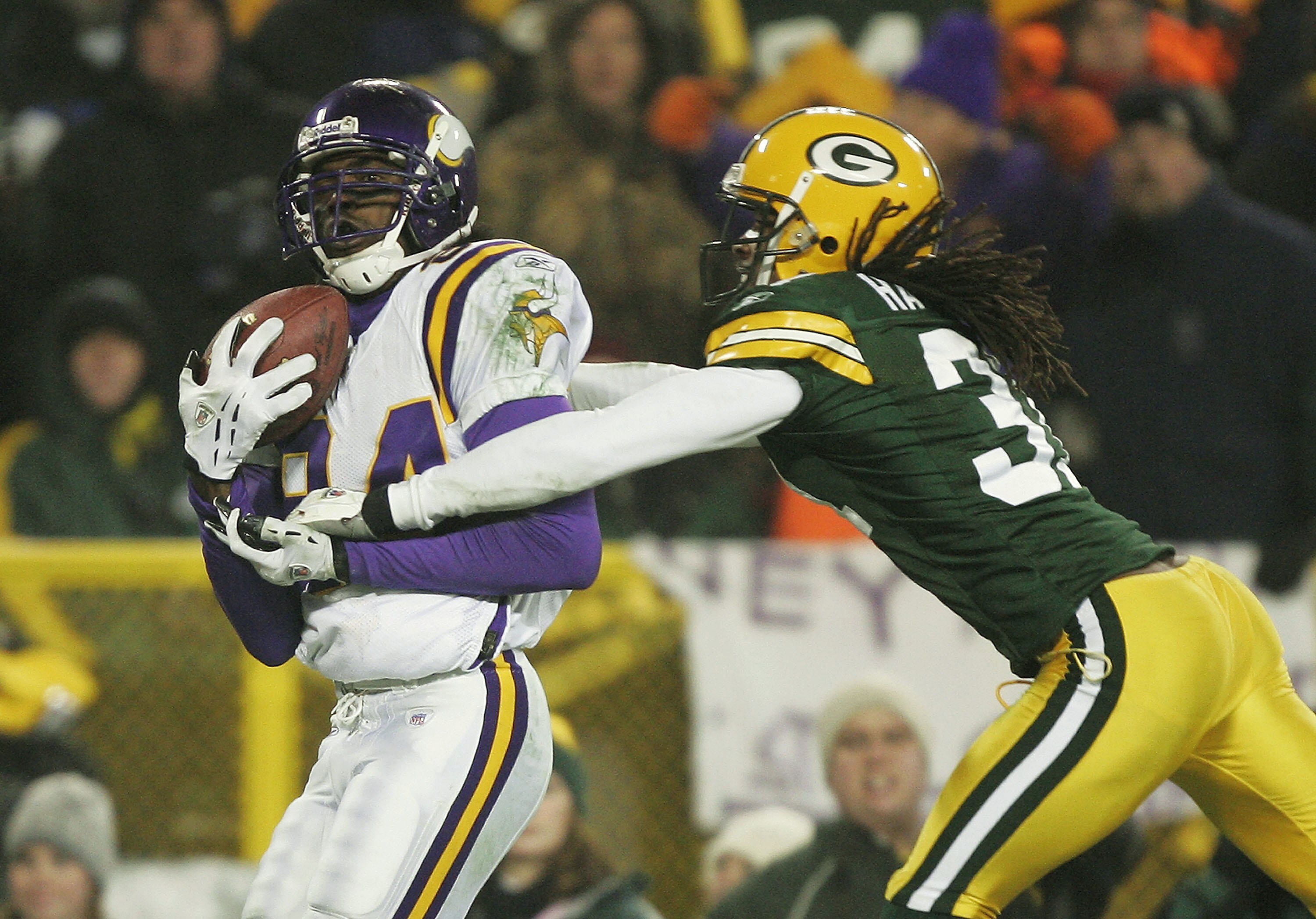 GREEN BAY, WI - JANUARY 9:  Wide receiver Randy Moss #84 of the Minnesota Vikings catches a second half touchdown pass in front of cornerback Al Harris #31 of the Green Bay Packers during the NFC wild-card game at Lambeau Field January 9, 2005 in Green Ba