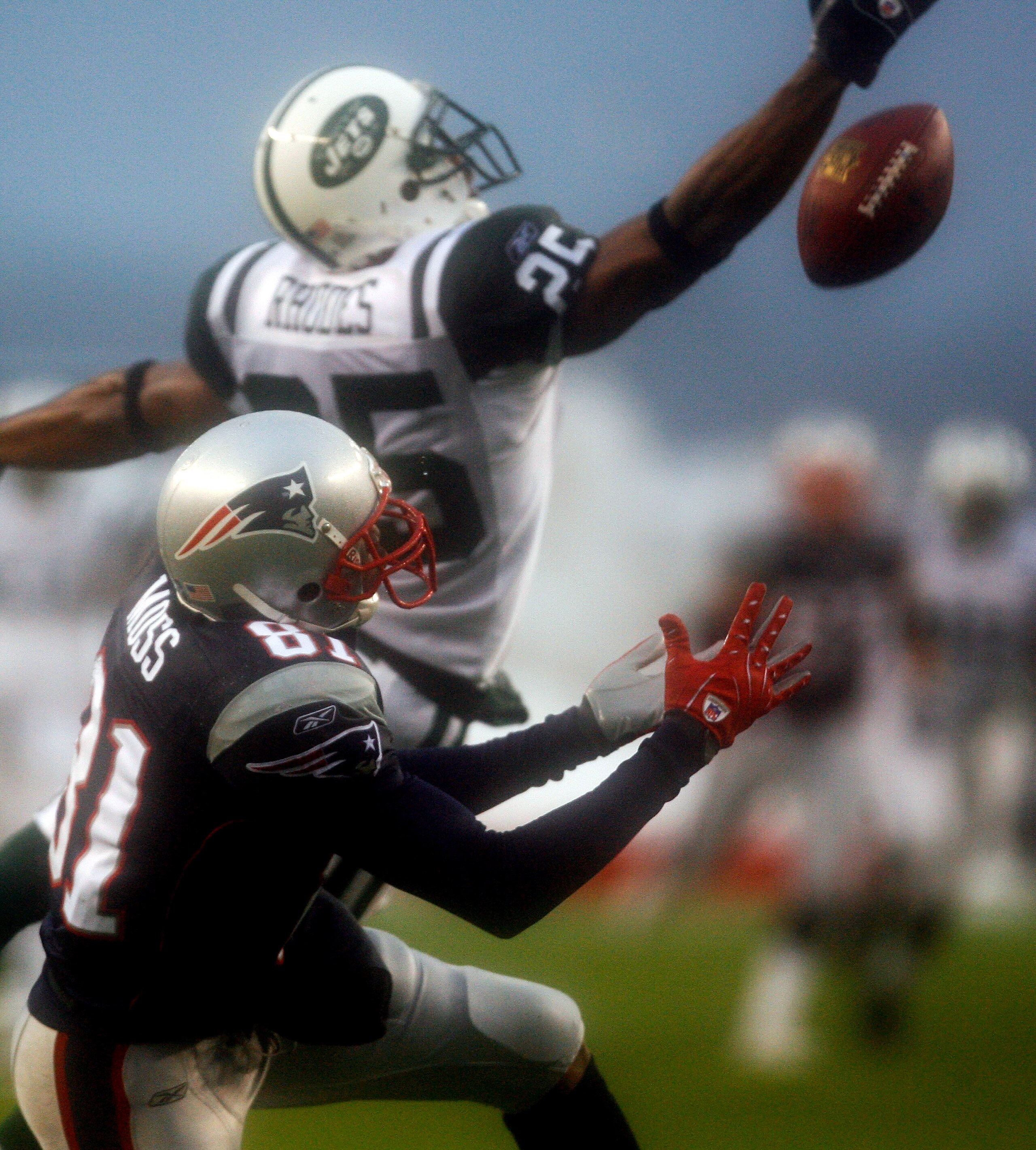 FOXBORO, MA - DECEMBER 16:  Randy Moss #81 of the New England Patriots snags a pass despite the defense of Kerry Rhodes #25 of the New York Jets leaves the field after shaking the hand of coach Bill Belichick at Gillette Stadium on December 16, 2007 in Fo