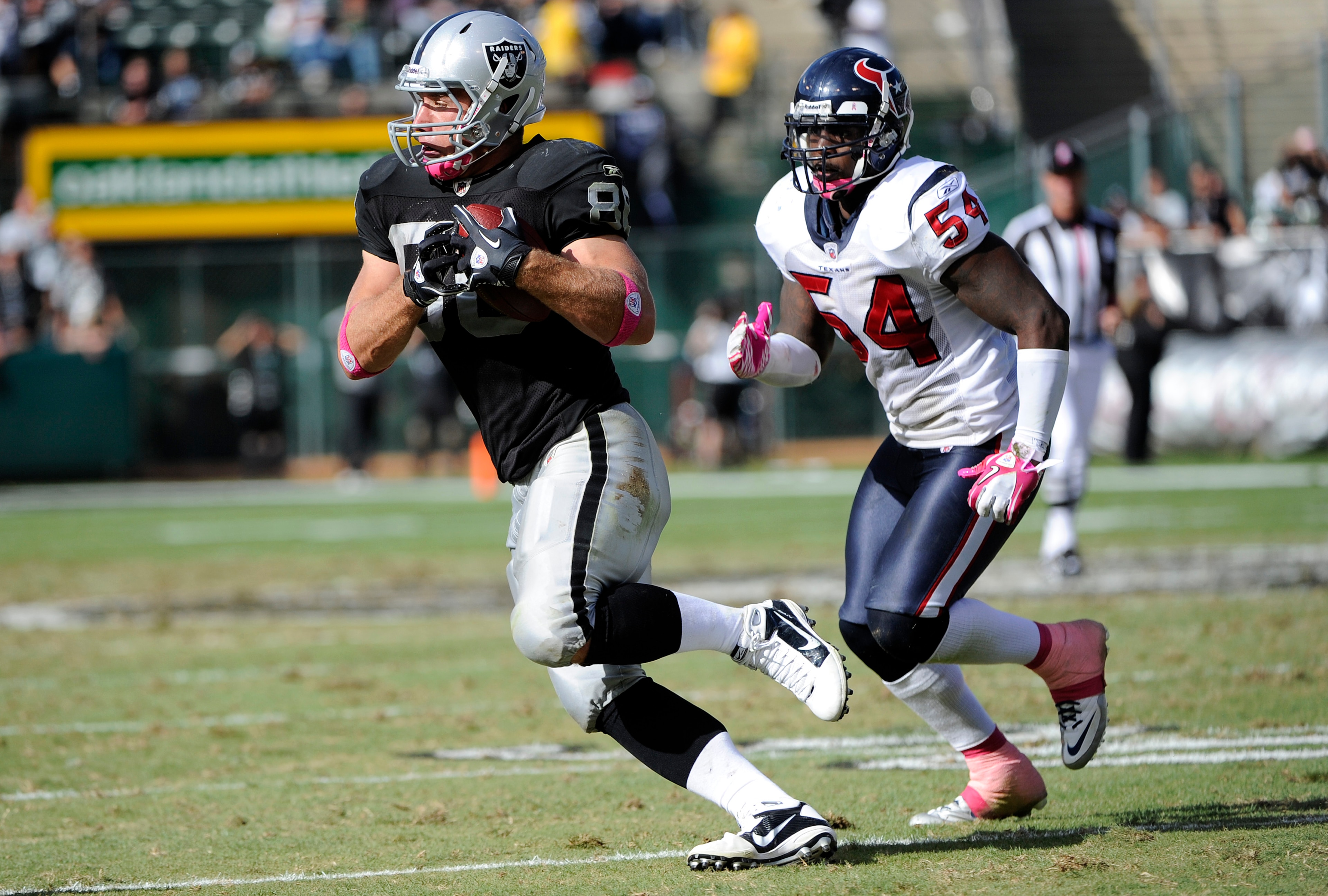 OAKLAND, CA - OCTOBER 3:  Tight end Zach Miller #80 of the Oakland Raiders catches a pass in front of linebacker Zac Diles #54 of the Houston Texans during an NFL football game October 3, 2010 at The Oakland-Alameda County Coliseum in Oakland, California.