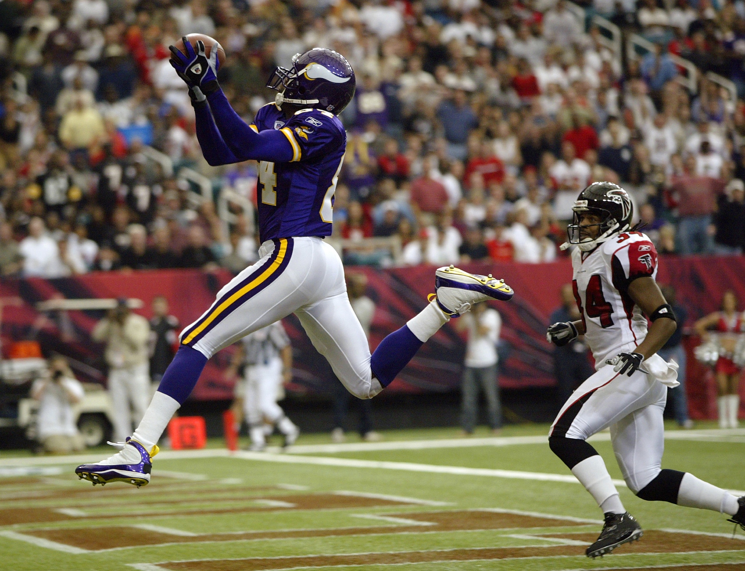 ATLANTA - OCTOBER 5:  Wide receiver Randy Moss #84 of the Minnesota Vikings goes up to get a touchdown pass over his head against cornerback Ray Buchanan #34 of the Atlanta Falcons in the first half October 5, 2003 at the Georgia Dome in Atlanta, Georgia.
