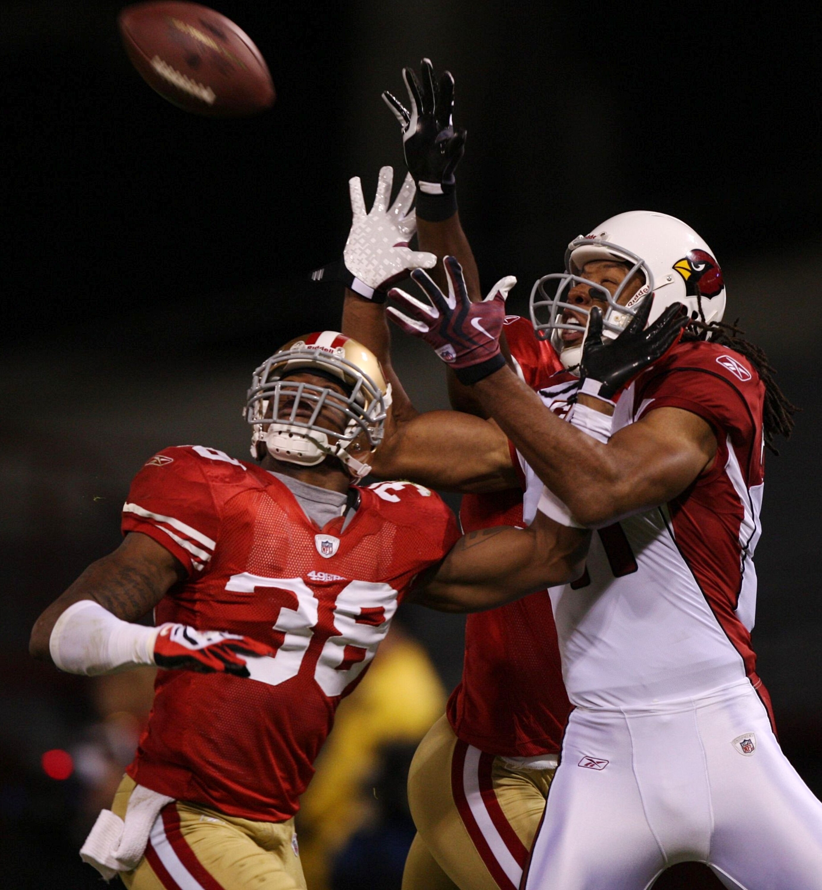 SAN FRANCISCO - DECEMBER 14:  Wide receiver Larry Fitzgerald #11 of the Arizona Cardinals goes up for a catch as it is broken up by Dashon Goldson #38 of the San Francisco 49ers in the first half at Candlestick Park on December 14, 2009 in San Francisco,