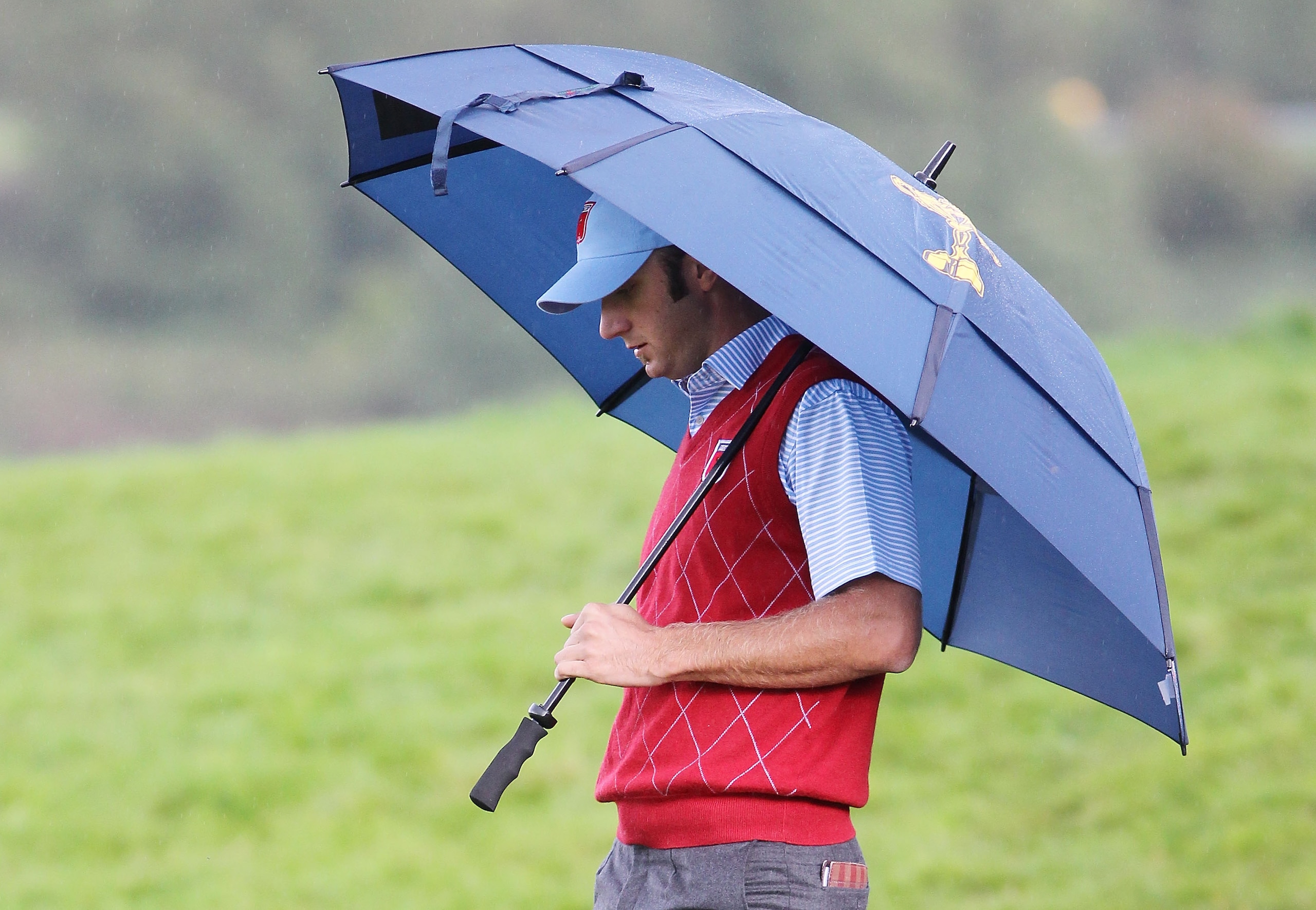 NEWPORT, WALES - OCTOBER 03:  Dustin Johnson of the USA waits under an umbrella during the Fourball & Foursome Matches during the 2010 Ryder Cup at the Celtic Manor Resort on October 3, 2010 in Newport, Wales.  (Photo by Jamie Squire/Getty Images)