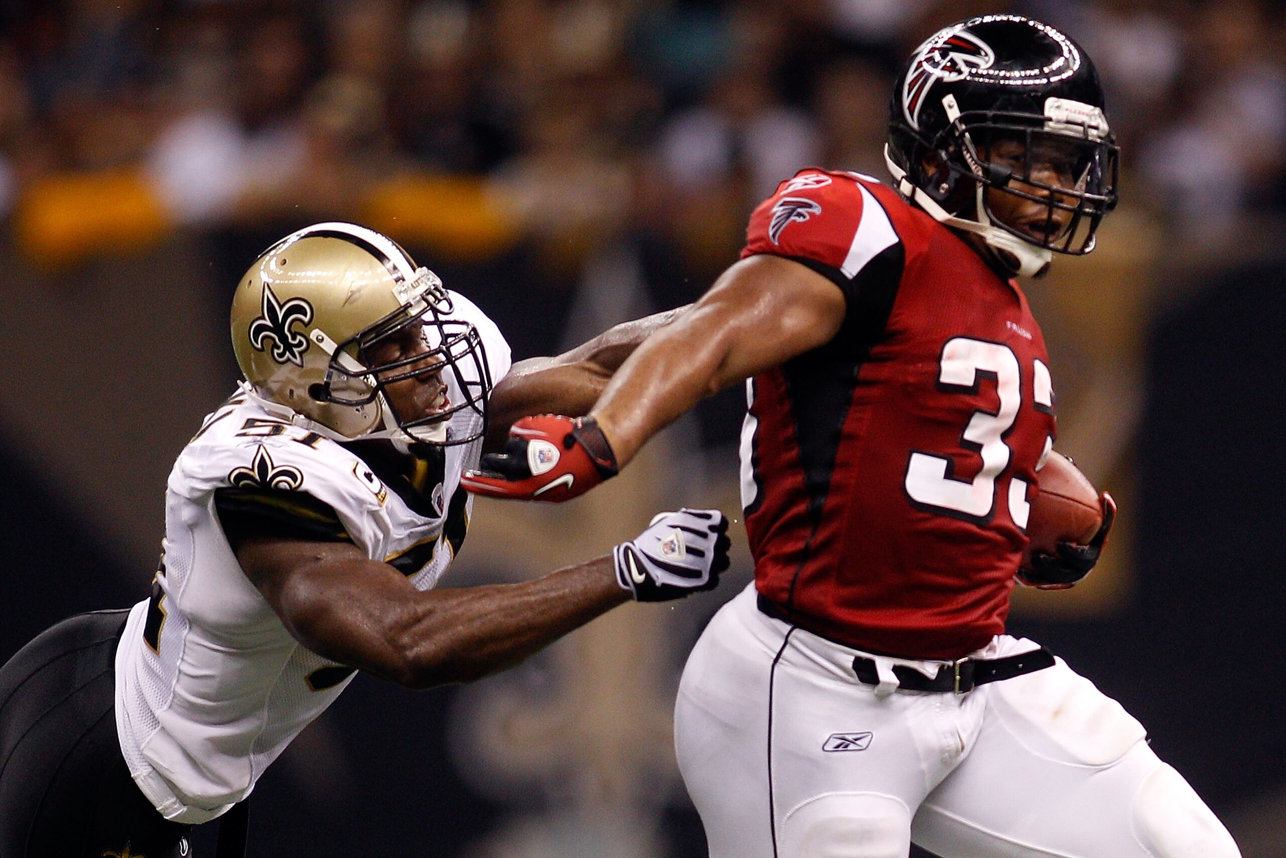 NEW ORLEANS - SEPTEMBER 26:  Michael Turner #33  of the Atlanta Falcons avoids a tackle by Jonathan Vilma #51 of the New Orleans Saints at the Louisiana Superdome on September 26, 2010 in New Orleans, Louisiana.  (Photo by Chris Graythen/Getty Images)