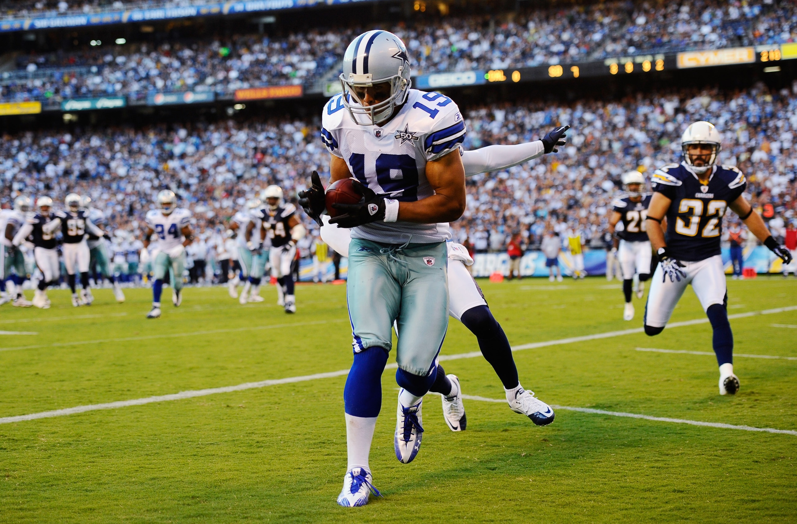 SAN DIEGO - AUGUST 21:  Wide receiver Miles Austin #19 of the Dallas Cowboys catches a touchdown pass against corner back Quentin Jammer #23 of the San Diego Chargers during their preseason NFL football game at Qualcomm Stadium on August 21, 2010 in San D