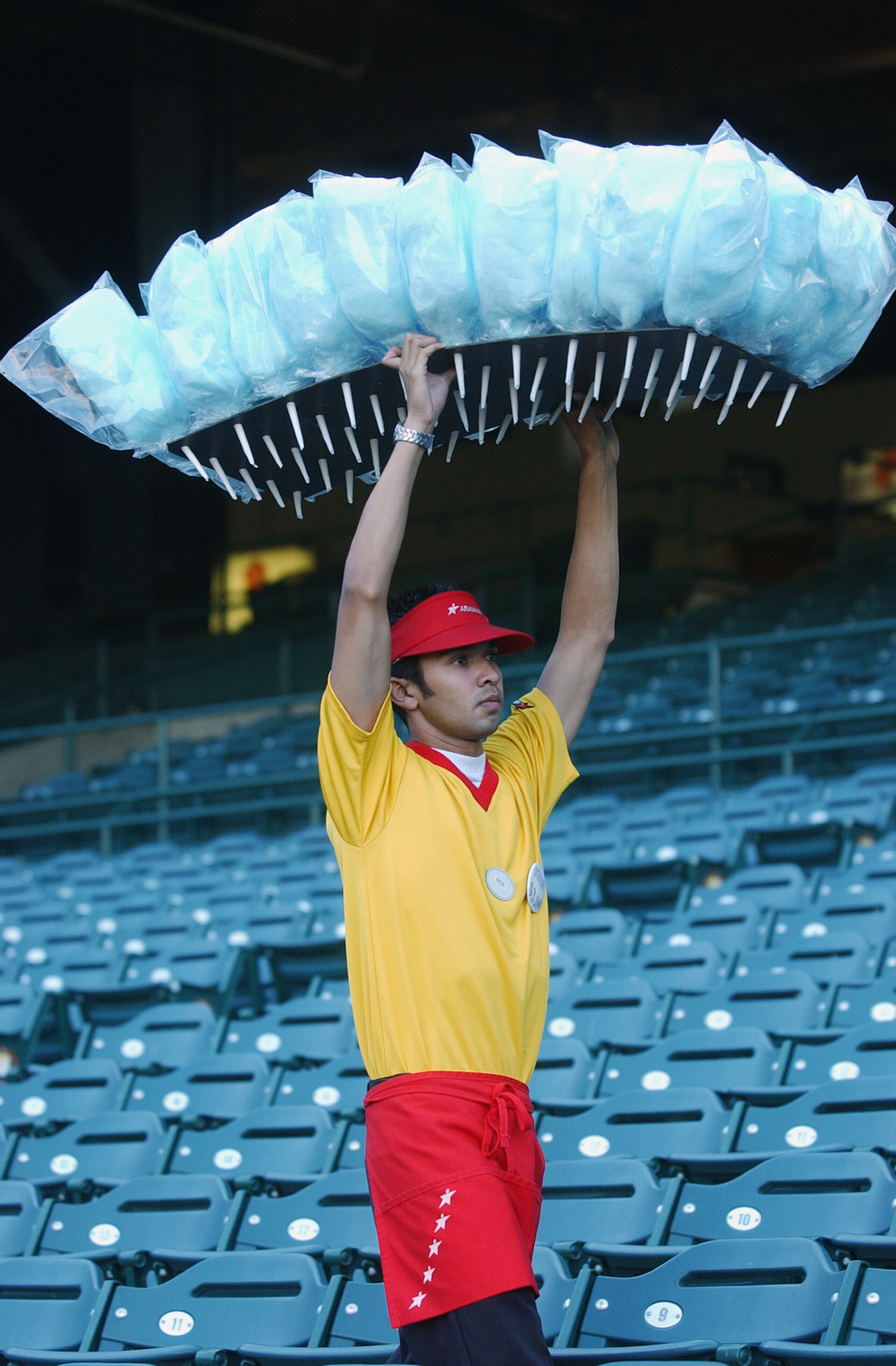 ANAHEIM, CA - AUGUST 29: Cotton Candy vendor Nick Negron carries his candy in front of empty seats on the eve of a Major League Baseball strike before the game between the Tampa Bay Devil Rays and the Anaheim Angels at Edison Field on August 29, 2002 in ANAHEIM, CA - AUGUST 29: Cotton Candy vendor Nick Negron carries his candy in front of empty seats on the eve of a Major League Baseball strike before the game between the Tampa Bay Devil Rays and the Anaheim Angels at Edison Field on August 29, 2002 in