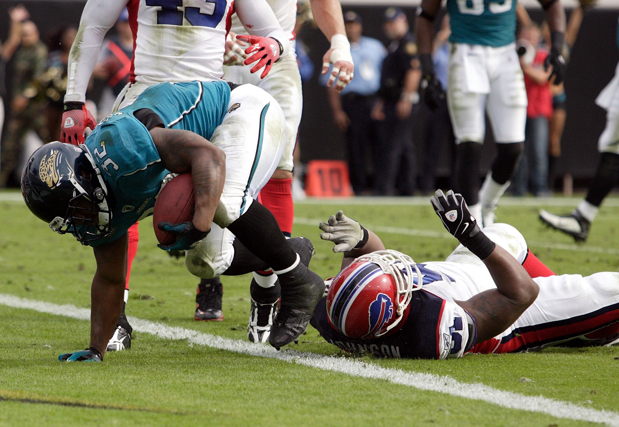 JACKSONVILLE, FL - NOVEMBER 22:  Running back  Maurice Jones Drew #32 of the Jacksonville Jaguars  is brought down by defenders of the Buffalo Bills at Jacksonville Municipal Stadium on November 22, 2009 in Jacksonville, Florida. Jacksonville defeated Buf
