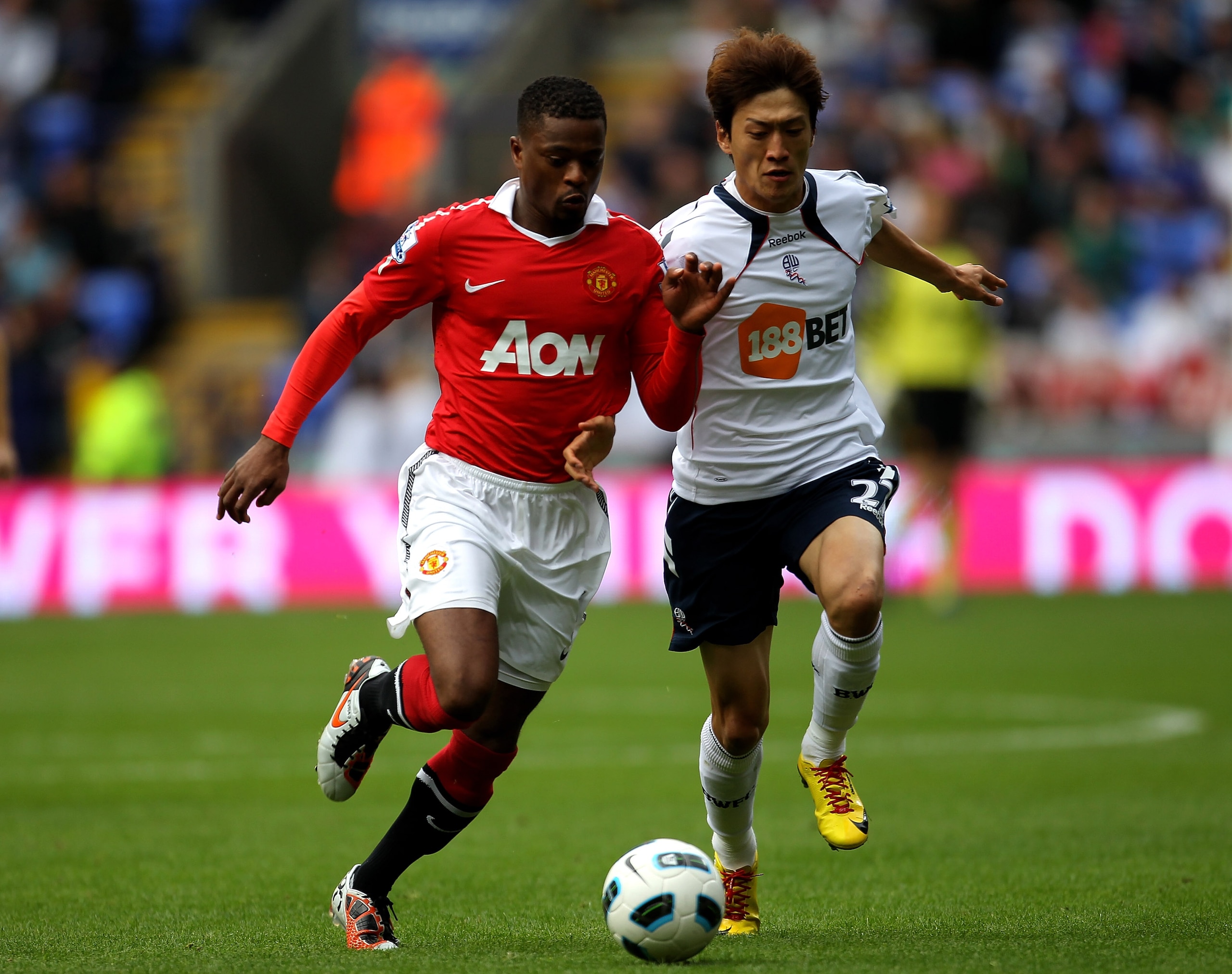 BOLTON, ENGLAND - SEPTEMBER 26:  Chung Yong Lee of Bolton Wanderers competes with Patrice Evra of Manchester United during the Barclays Premier League match between Bolton Wanderers and Manchester United at the Reebok Stadium on September 26, 2010 in Bolt