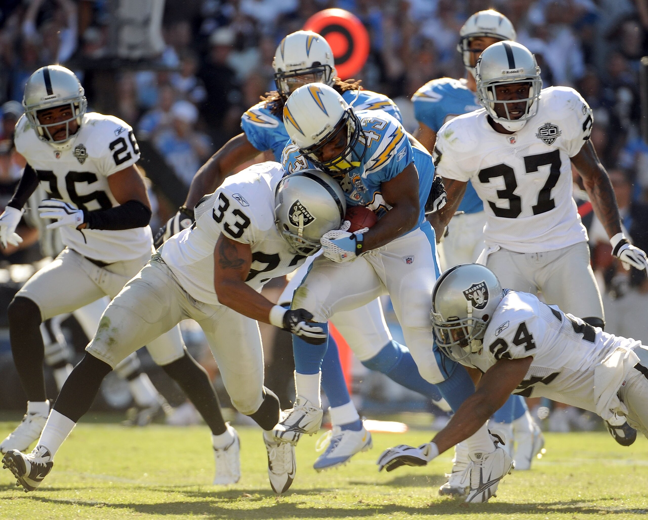SAN DIEGO - NOVEMBER 01:  Darren Sproles #43 of the San Diego Chargers gets hit by Tyvon Branch #33 and Michael Huff #24 of the Oakland Raiders during the game at Qualcomm Stadium on November 1, 2009 in San Diego California. The Chargers defeated the Raid