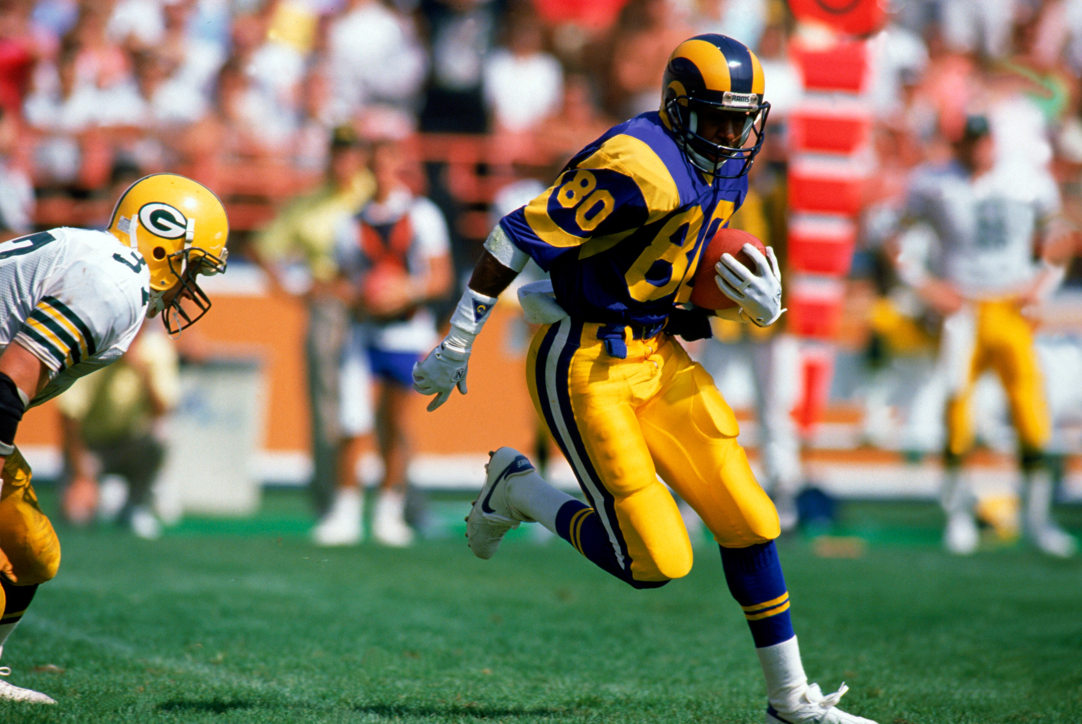 ANAHEIM, CA - SEPTEMBER 24:  Wide receiver Henry Ellard #80 of the Los Angeles Rams carries the ball for yards against the Green Bay Packers during an NFL game at Anaheim Stadium on September 24, 1989 in Anaheim, California. The Rams defeated the Packers