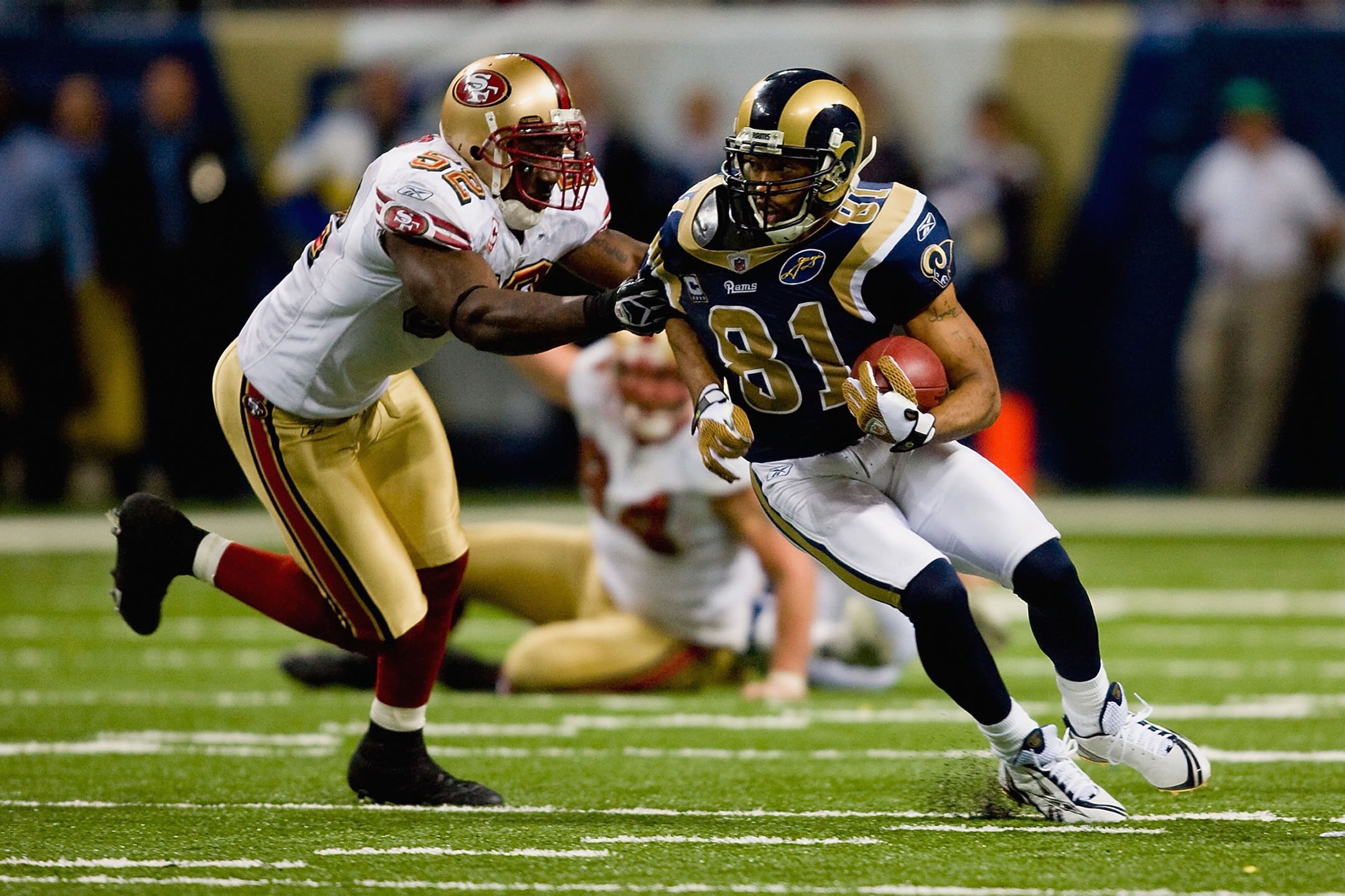 ST. LOUIS, MO - DECEMBER 21:  Torry Holt #81 of the St. Louis Rams carries the ball against Patrick Willis #52 of the San Francisco 49ers at the Edward Jones Dome on December 21, 2008 in St. Louis, Missouri. The 49ers won 17-16. (Photo by Dilip Vishwanat/