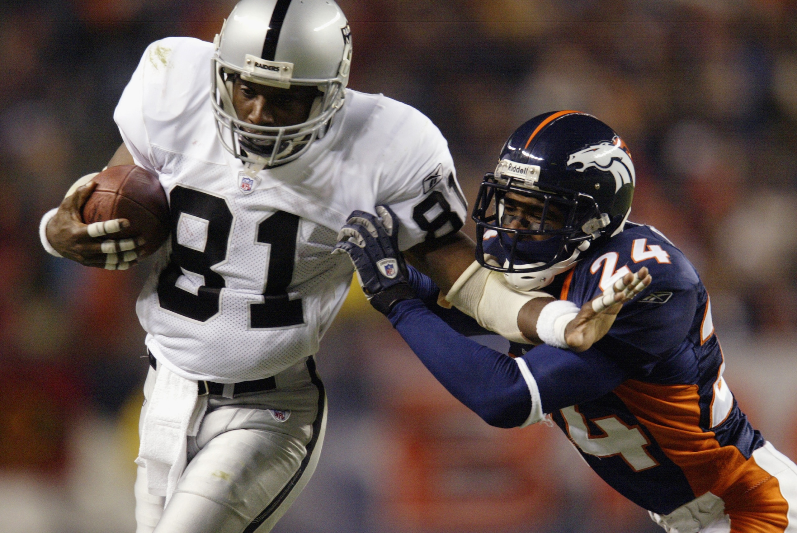 DENVER, CO - NOVEMBER 11:  Wide receiver Tim Brown #81 of the Oakland Raiders takes the ball to the sidelines against the Denver Broncos in the third quarter of Monday Night Football November 11, 2002 at Mile High Stadium in Denver, Colorado.  The Raiders