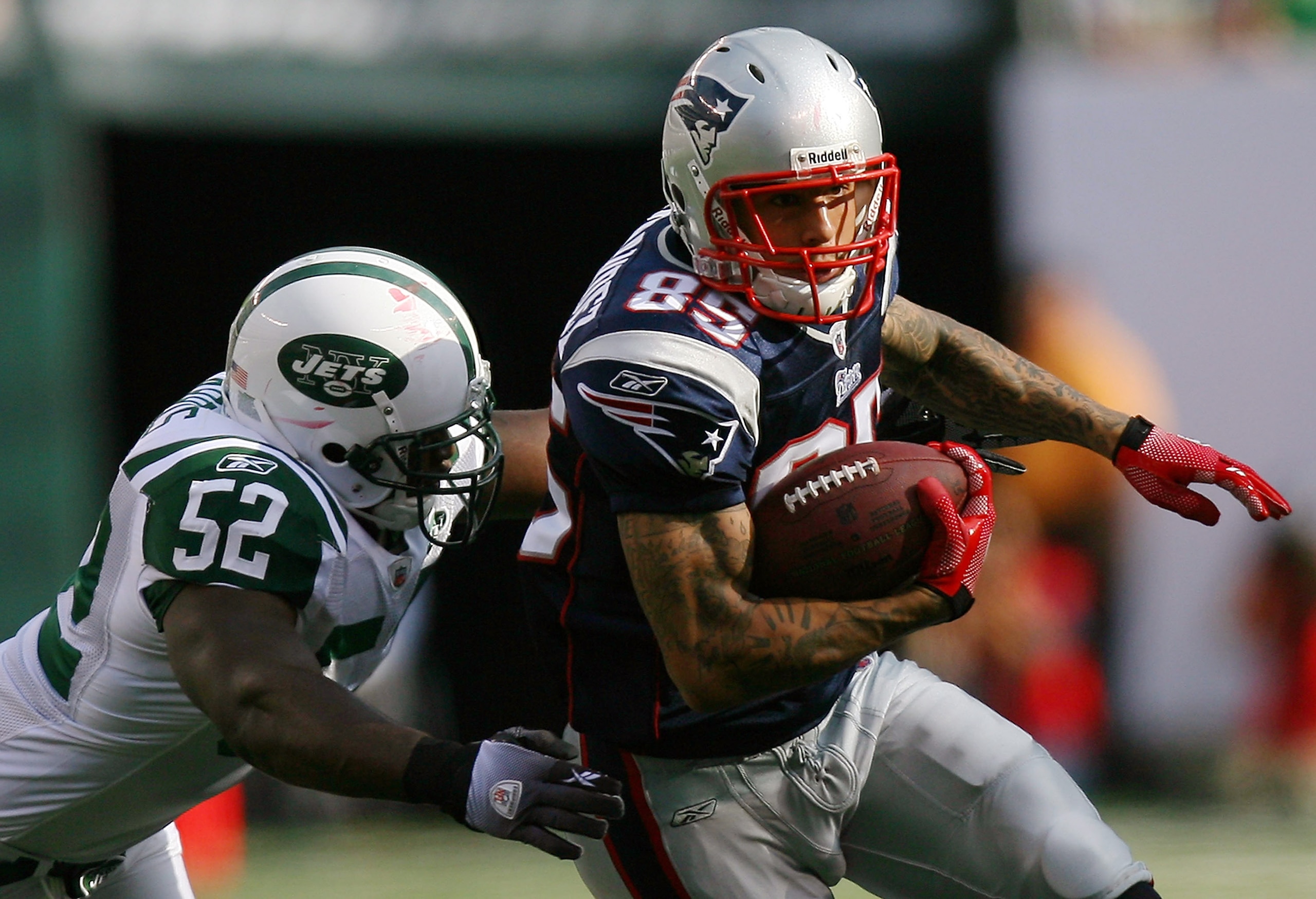EAST RUTHERFORD, NJ - SEPTEMBER 19:  David Harris #52 of the New York Jets attempts to tackle Aaron Hernandez #85 of the New England Patriots during the first quarter at the New Meadowlands Stadium on September 19, 2010 in East Rutherford, New Jersey.  (P