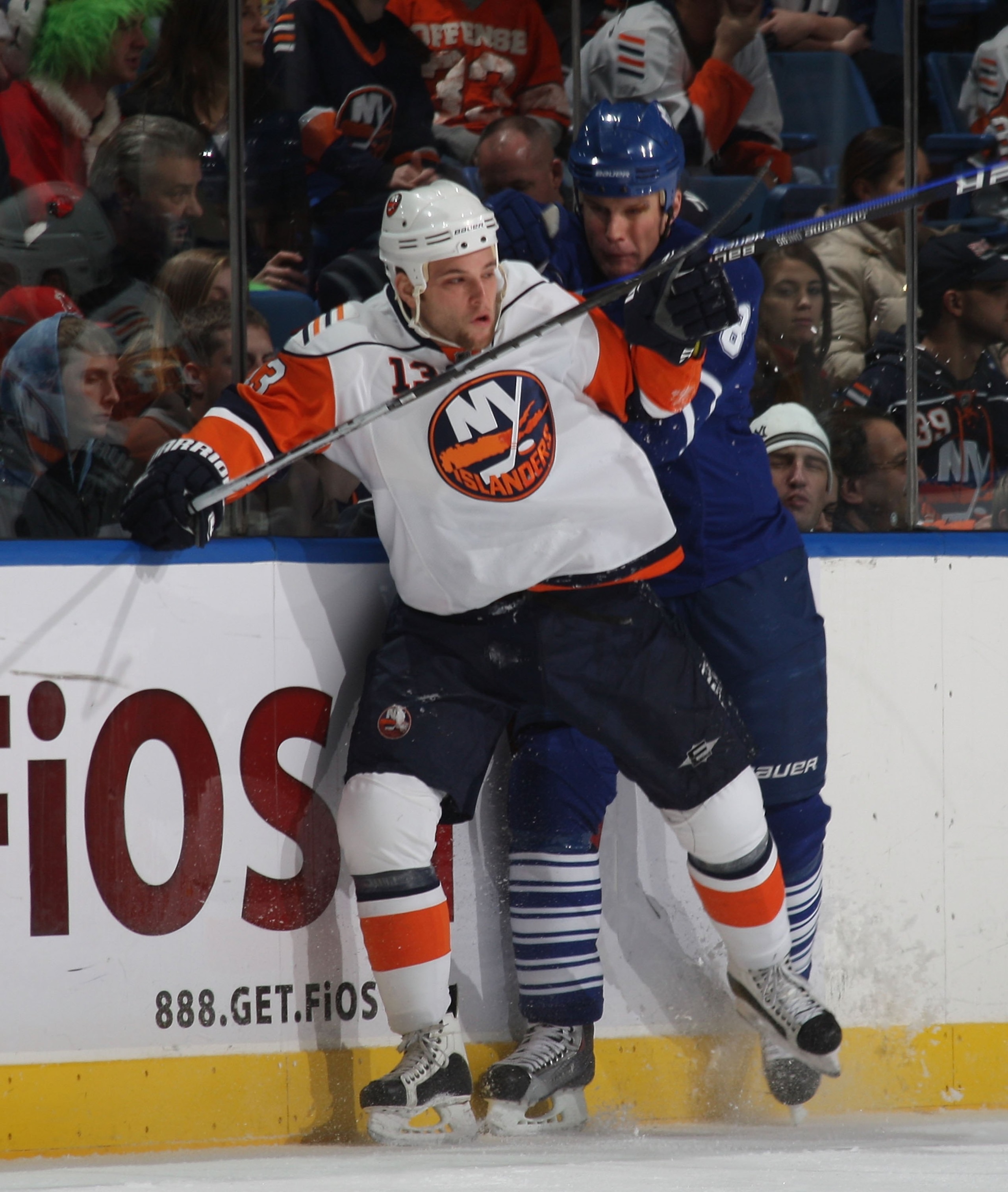 UNIONDALE, NY - DECEMBER 23: Jon Sim #16 of the New York Islanders is hit by Mike Komisarek #8 of the Toronto Maple Leafs at Nassau Coliseum on December 23, 2009 in Uniondale, New York. (Photo by Bruce Bennett/Getty Images)
