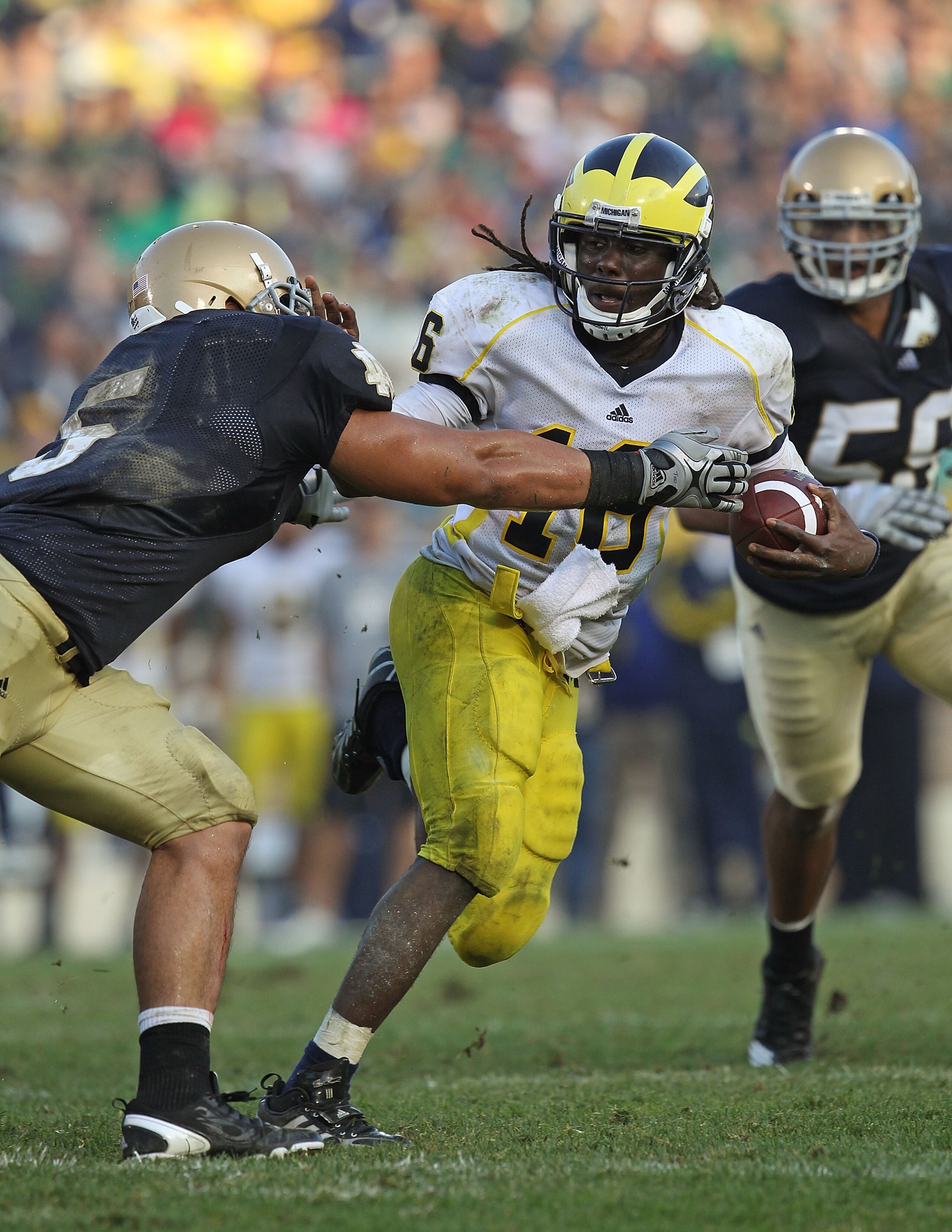 SOUTH BEND, IN - SEPTEMBER 11: Denard Robinson #16 of the Michigan Wolverines pushes off a tackle attempt by Manti Te'o #5 of the Notre Dame Fighting Irish in the final minute at Notre Dame Stadium on September 11, 2010 in South Bend, Indiana. Michigan de
