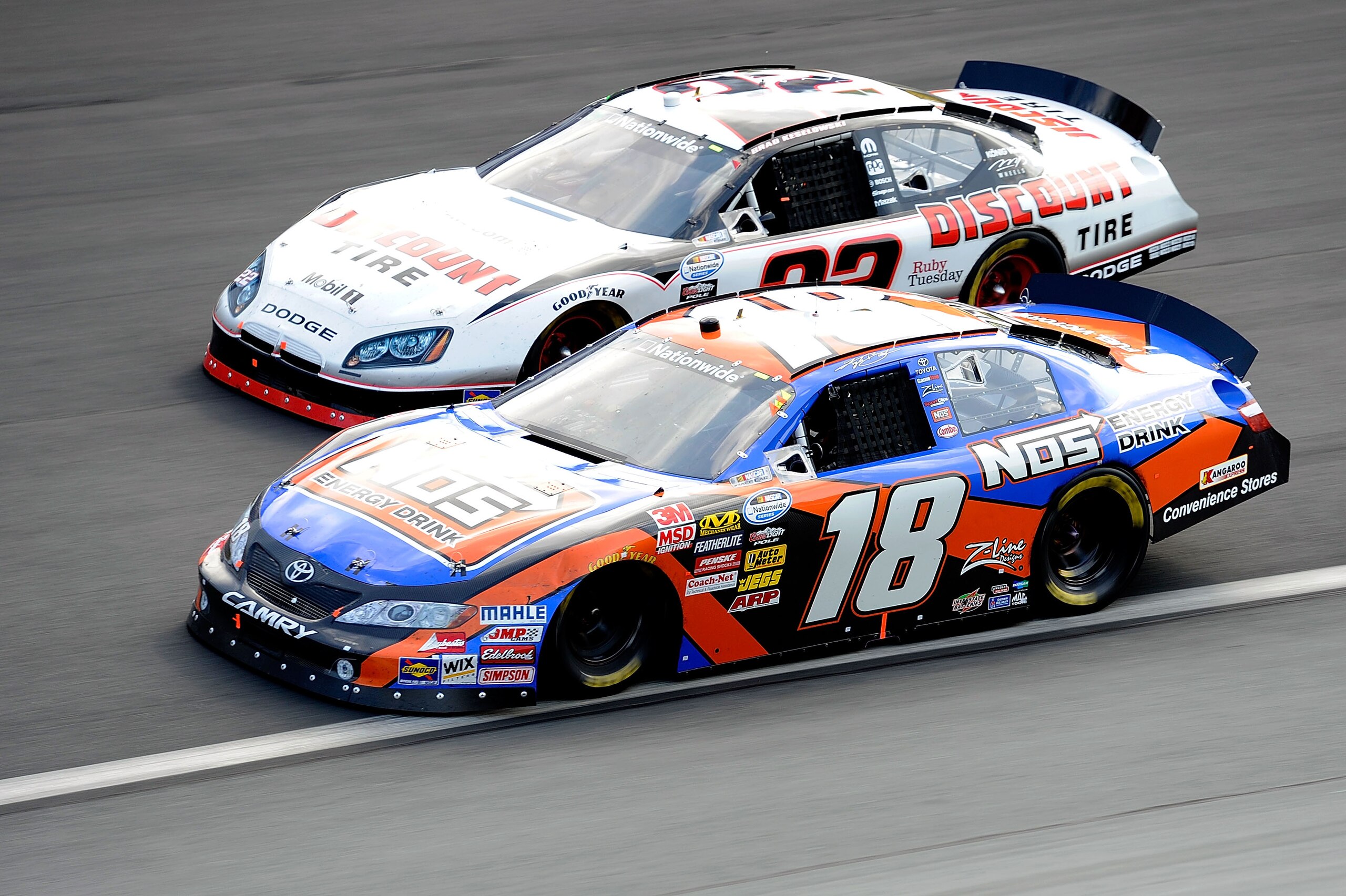 CONCORD, NC - MAY 29:  Kyle Busch, driver of the #18 NOS Energy Drink Toyota, and Brad Keselowski, driver of the #22 Discount Tire Dodge, race side by side during the NASCAR Nationwide Series Tech-Net Auto Service 300 at Charlotte Motor Speedway on May 29